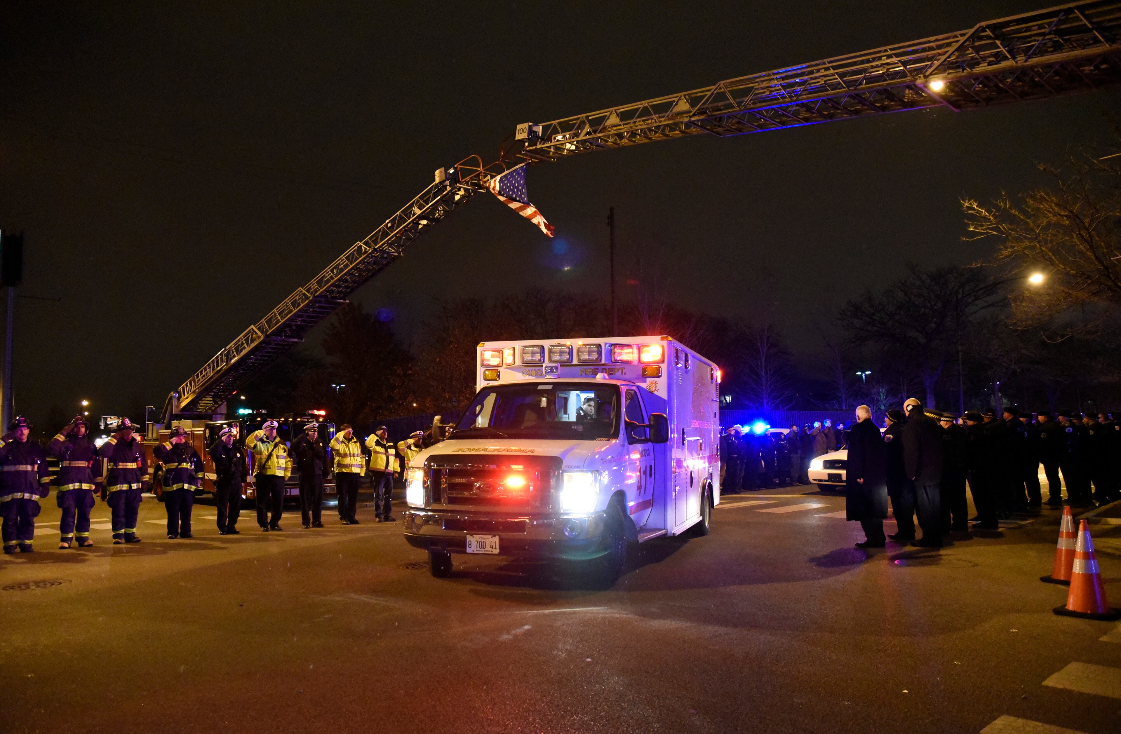 Chicago police officers and firefighters form an honor guard as the body of Chicago Police Officer Samuel Jimenez is brought to the coroner Monday, Nov. 19, 2018, in Chicago. A gunman opened fire Monday at a Chicago hospital, killing the police officer and at least a few hospital employees in an attack that began with a domestic dispute and exploded into a firefight with law enforcement inside the medical center. The suspect was also dead, authorities said. (AP Photo/David Banks)