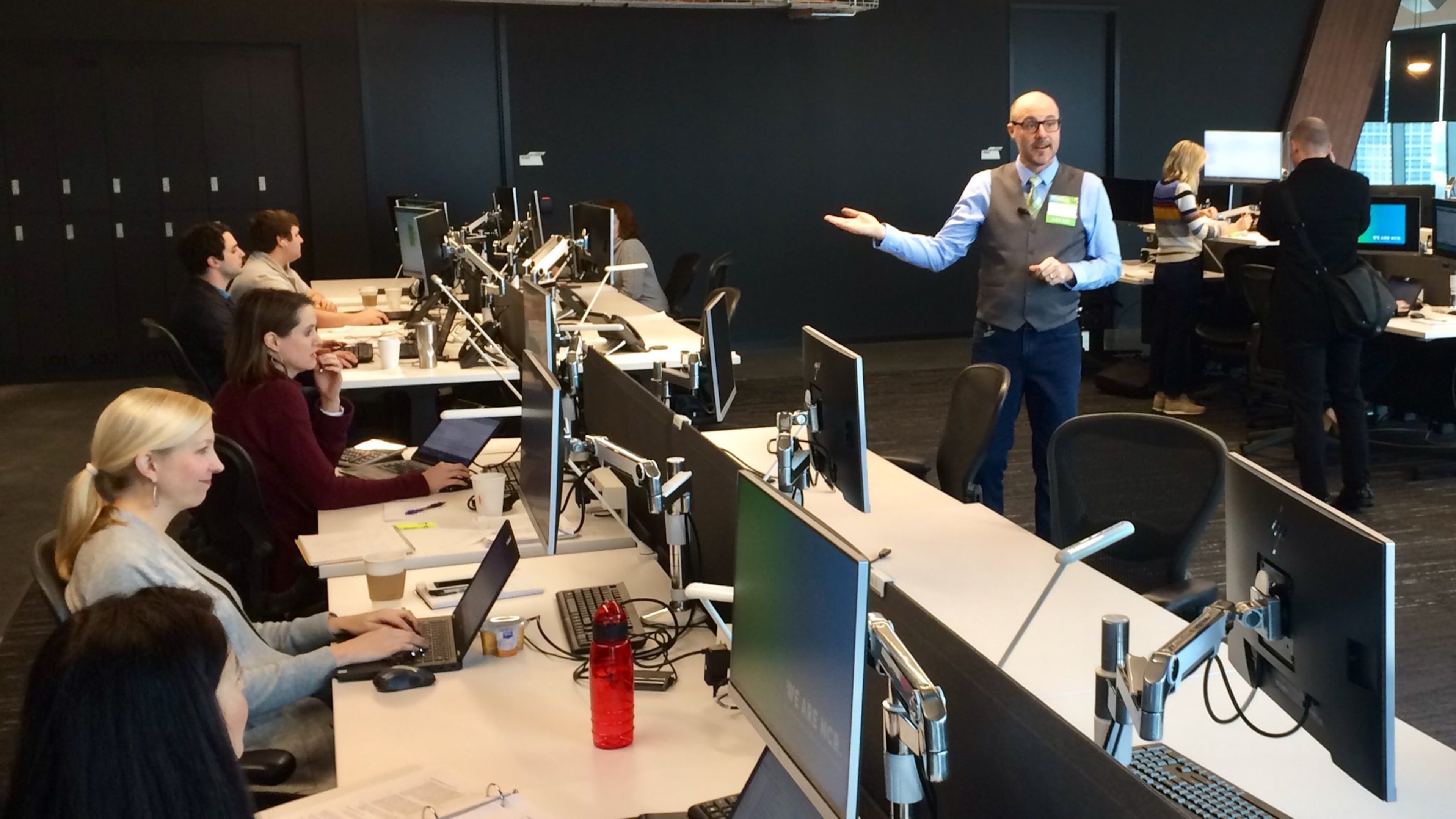 Kevin Finke, right, an NCR executive and head of campus and cultural experiences, shows of some of the workstations in the financial technology company’s Midtown Atlanta headquarters, which opened in January 2017. Tuesday, Feb. 13, 2018. J. Scott Trubey/strubey@ajc.com