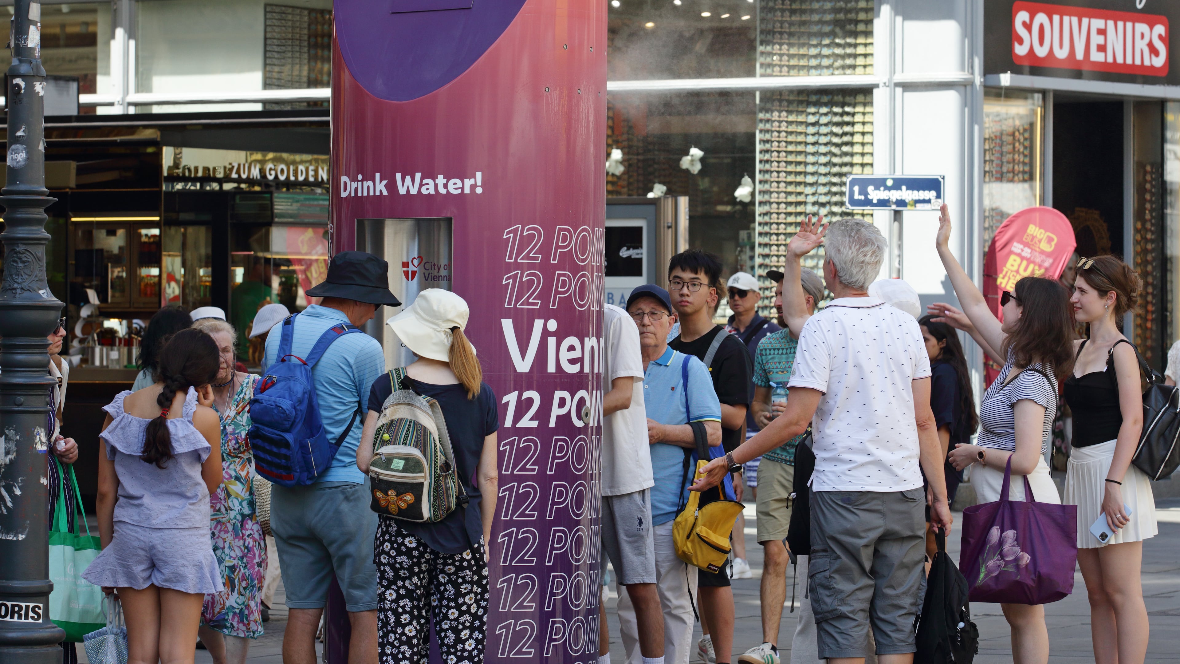 People line up to refill their water bottles on a hot summer day in the city center of Vienna, Austria, Saturday, June 27, 2026. (AP Photo/Heinz-Peter Bader)