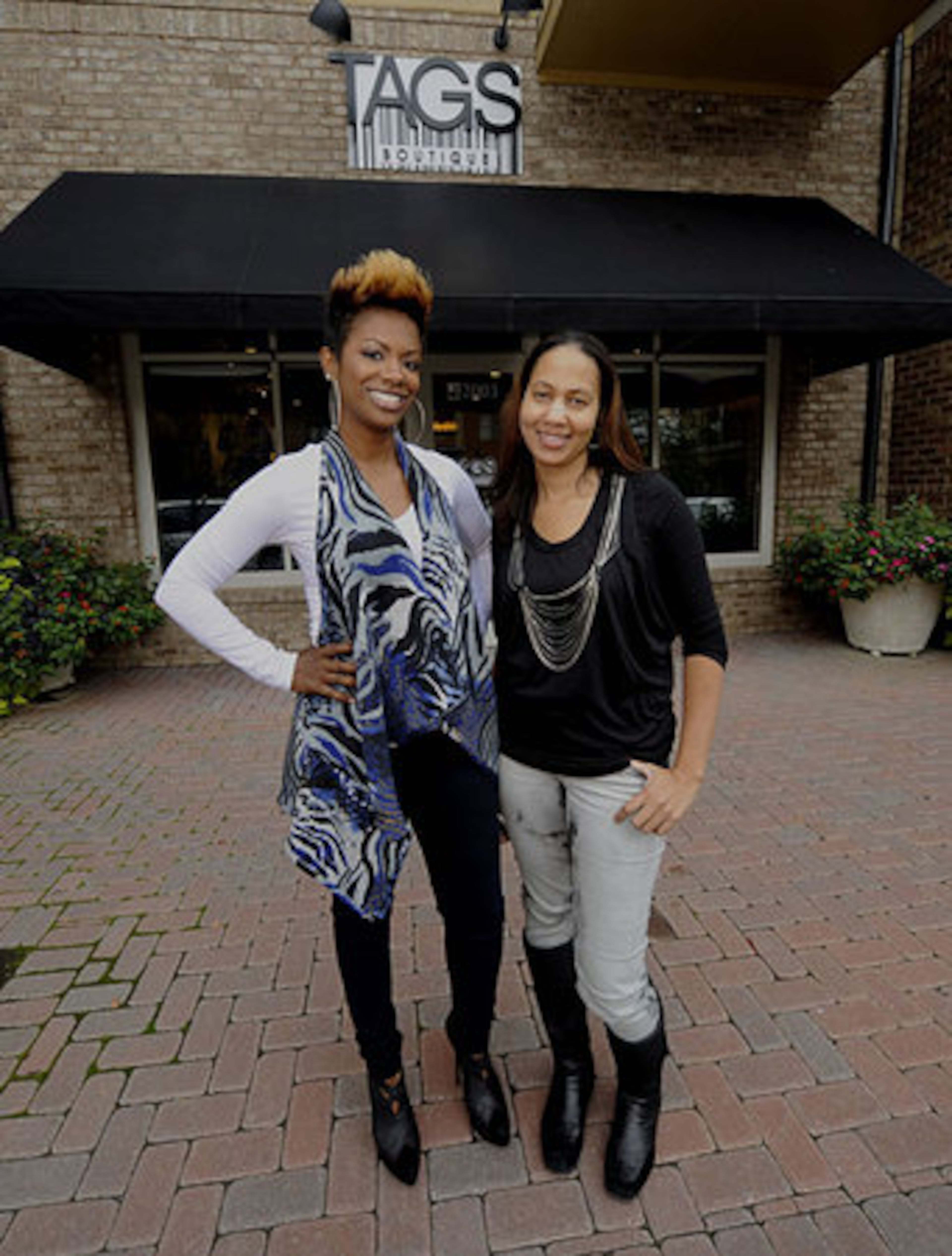 The Real Housewives of Atlanta's Kandi Burruss and Peaches Chin (right) stand outside Tags, their new boutique on Friday in Smyrna.