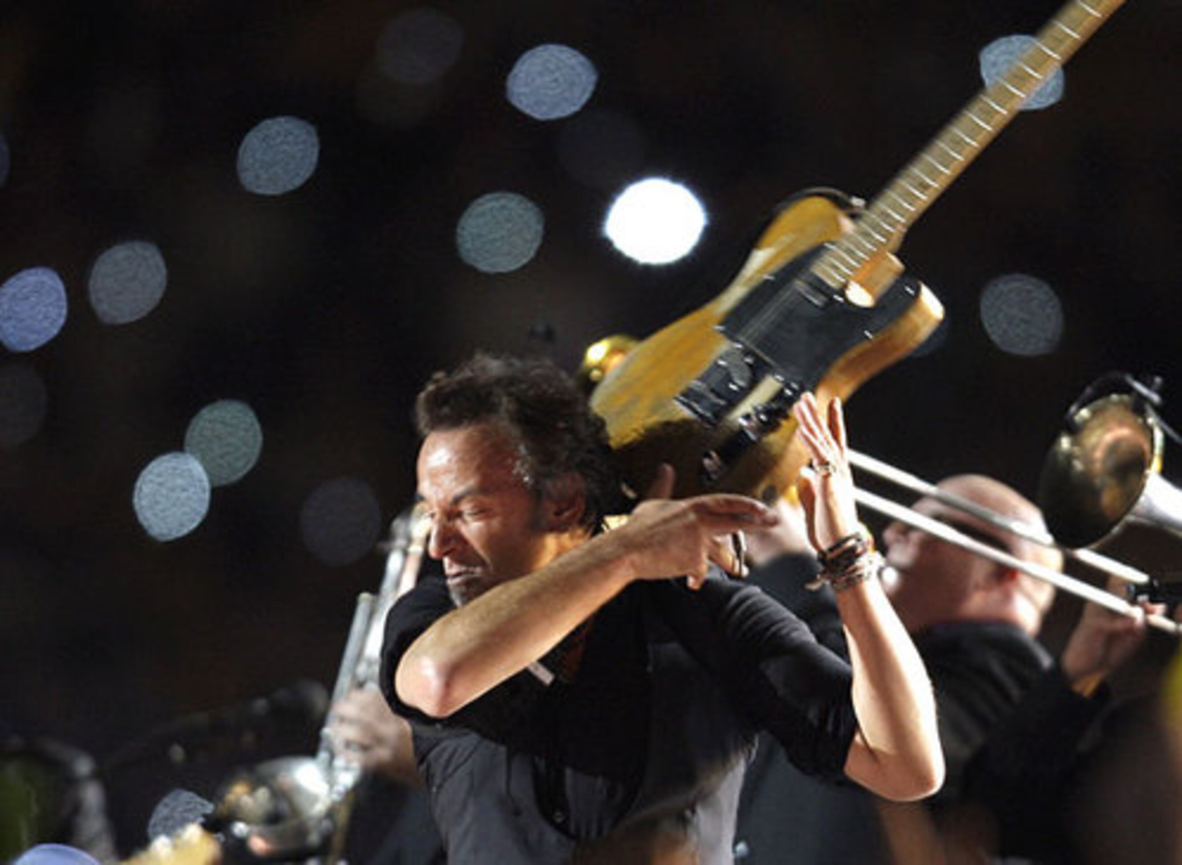 Without even choking himself, Bruce Springsteen does his spin-the-guitar-'round-his-neck trick.