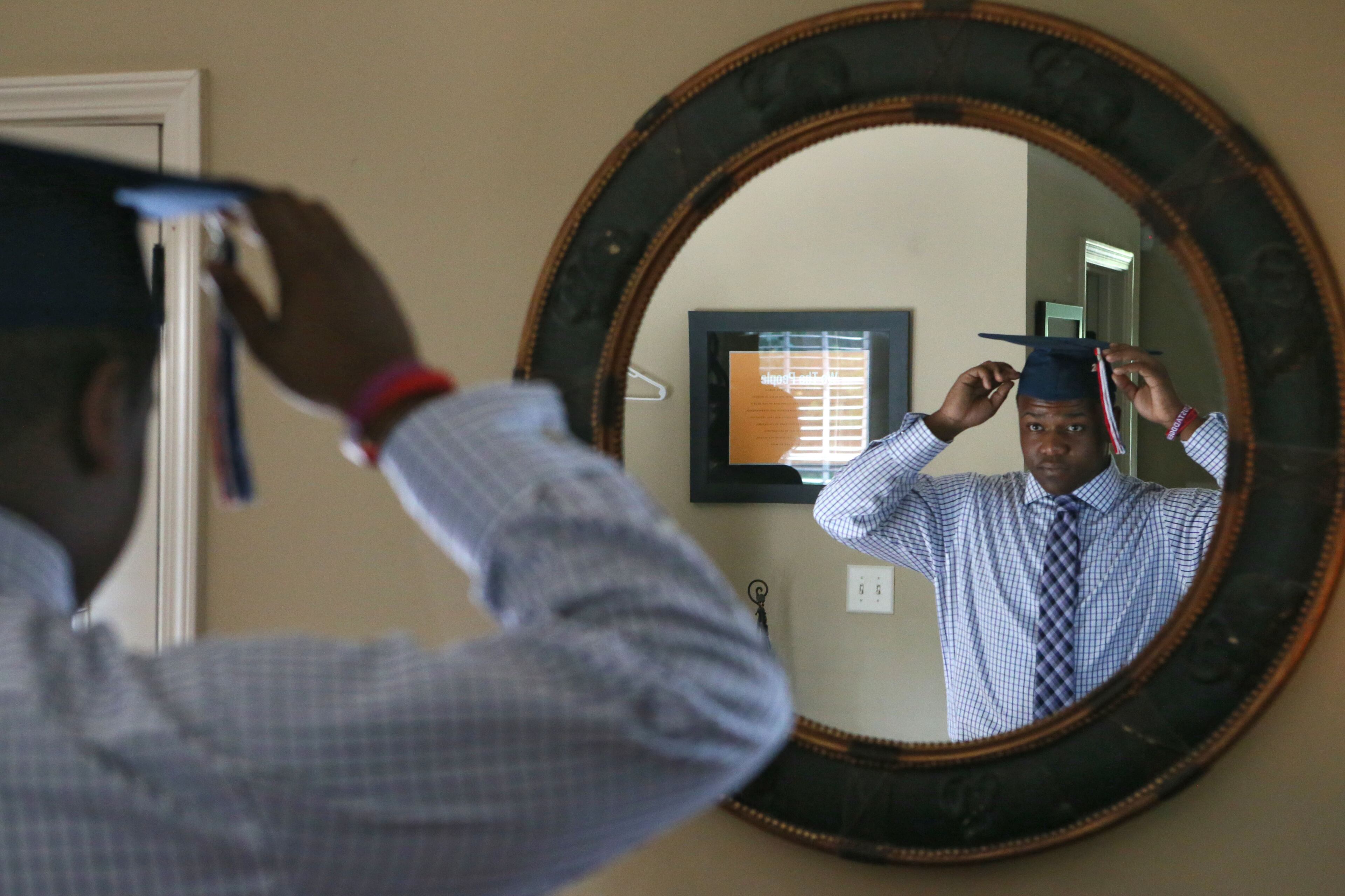 Ashton Jordan gets dressed for graduation. Since Ashton Jordan was 6 years old, Art Collins has been his mentor and has had lunch with him every week and still does. BOB ANDRES / BANDRES@AJC.COM