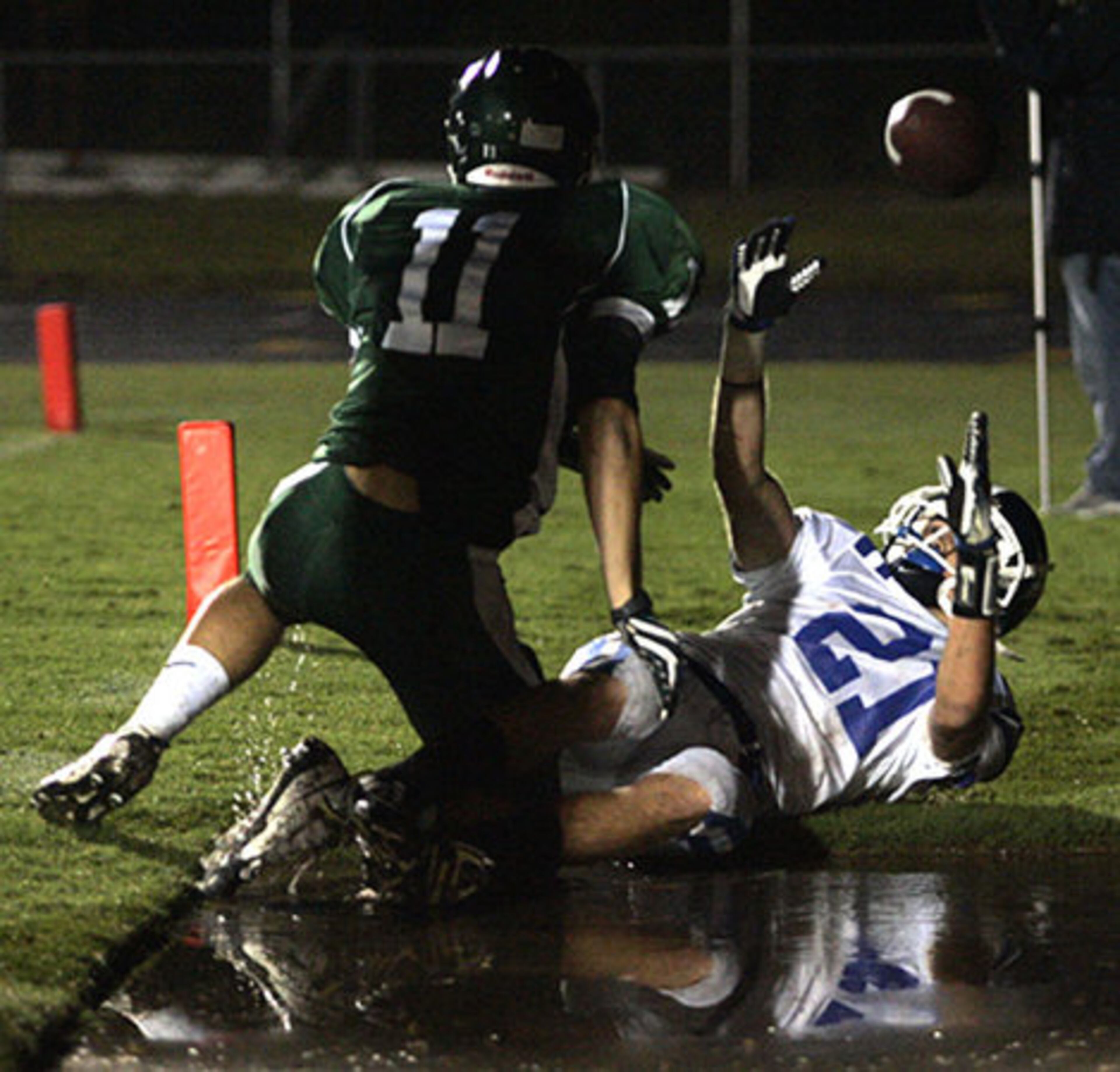 Peachtree Ridge Mitchell Williford (21)throws the ball in the air after landing in a puddle following a touchdown past Collins Hill Timmy Quinones (11).
