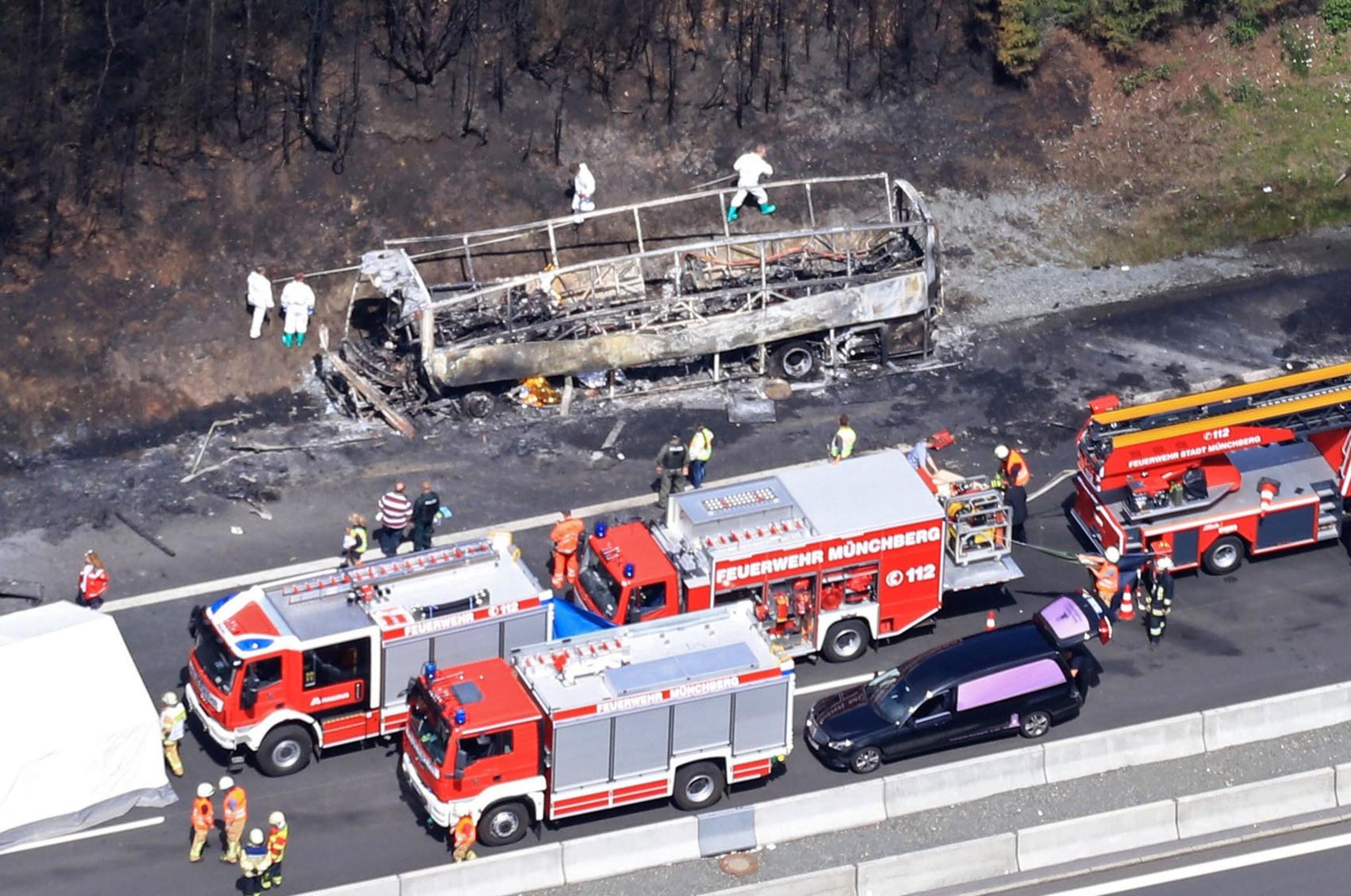 MUNCHBERG, BAYERN - JULY 03: (GERMANY OUT) In this aerial view fire and rescue workers stand near the burned-out wreckage of a passenger bus on the A9 highway in northern Bavaria on July 3, 2017 near Munchberg, Germany. Police have stated that the bus, which was carrying senior citizens from Saxony, crashed into a trailer truck and burst into flames. Police fear 18 people are dead and 30 injured in what is among Germany's worst bus accidents. (Photo by Stringer/Getty Images)