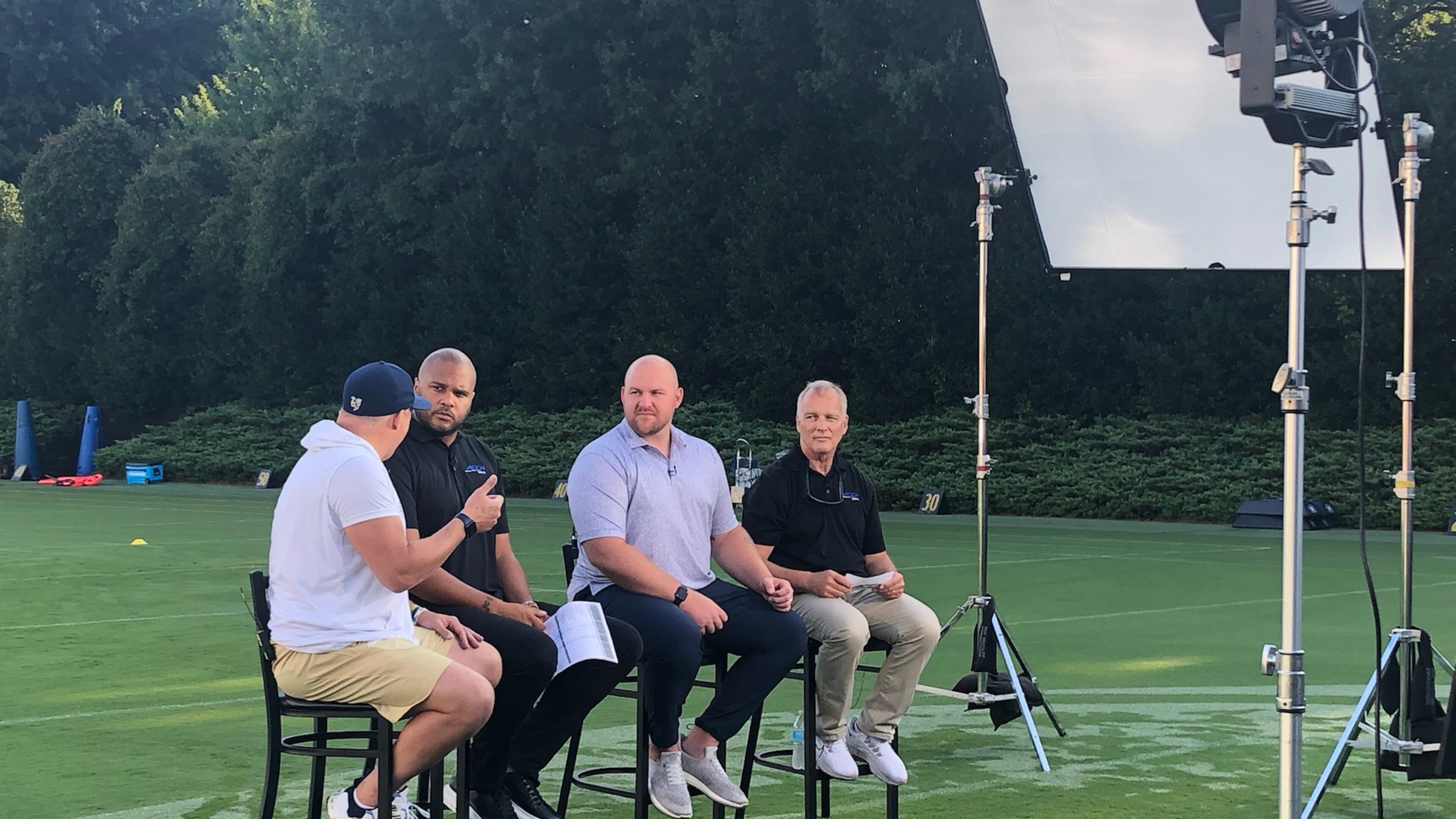 ACC Network analysts (from right to left) Mark Richt, Eric Mac Lain and Jordan Cornette listen to Georgia Tech coach Geoff Collins (in white shirt and shorts) during a taping of a program previewing Tech's season. (AJC photo by Ken Sugiura)