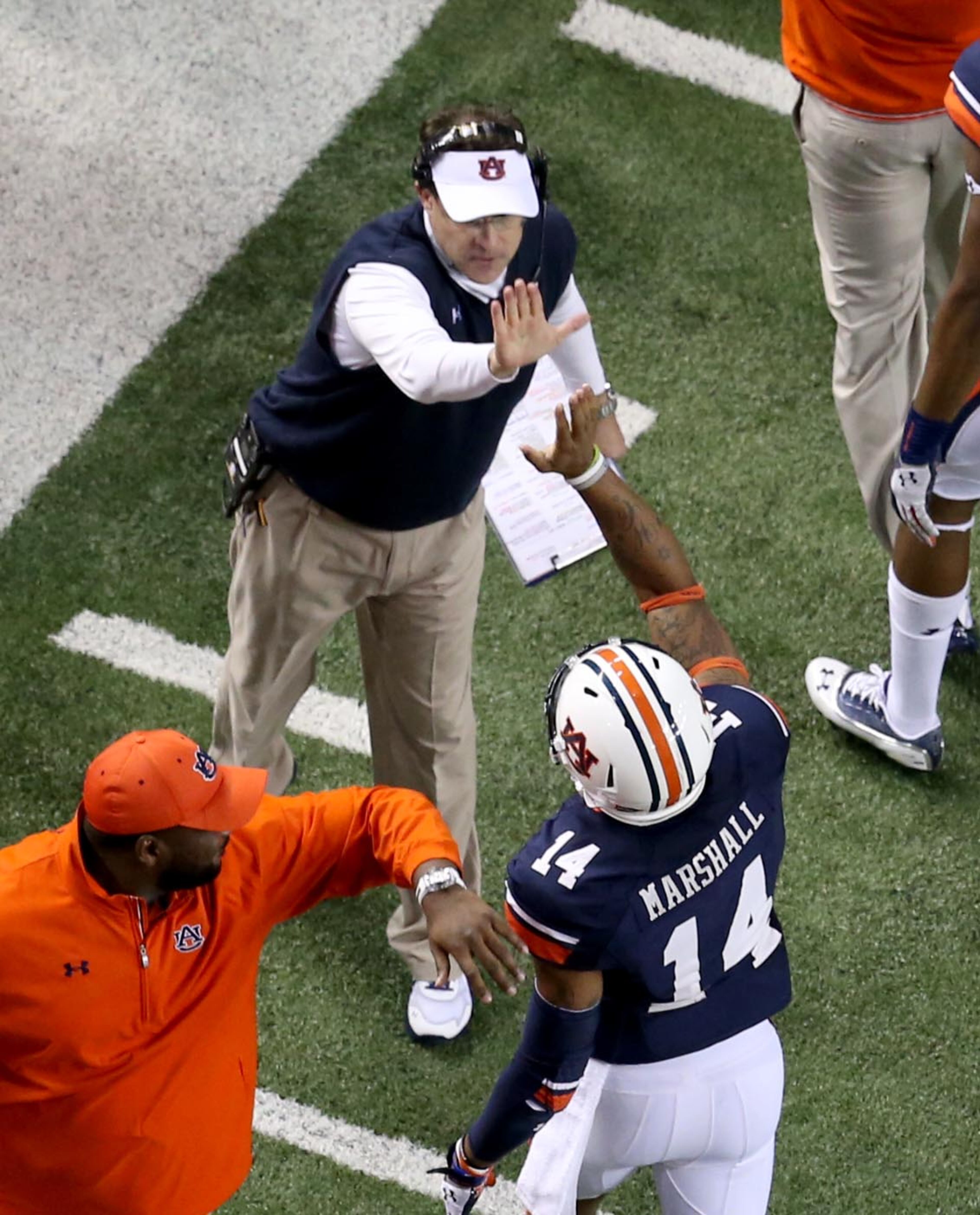 Auburn coach Gus Malzahn, top, high fives quarterback Nick Marshall (14) after an Auburn touchdown in the third quarter of Auburn's 59-42 win over Missouri in the SEC Championship Saturday night in Atlanta, Ga., December 7, 2013. JASON GETZ / JGETZ@AJC.COM