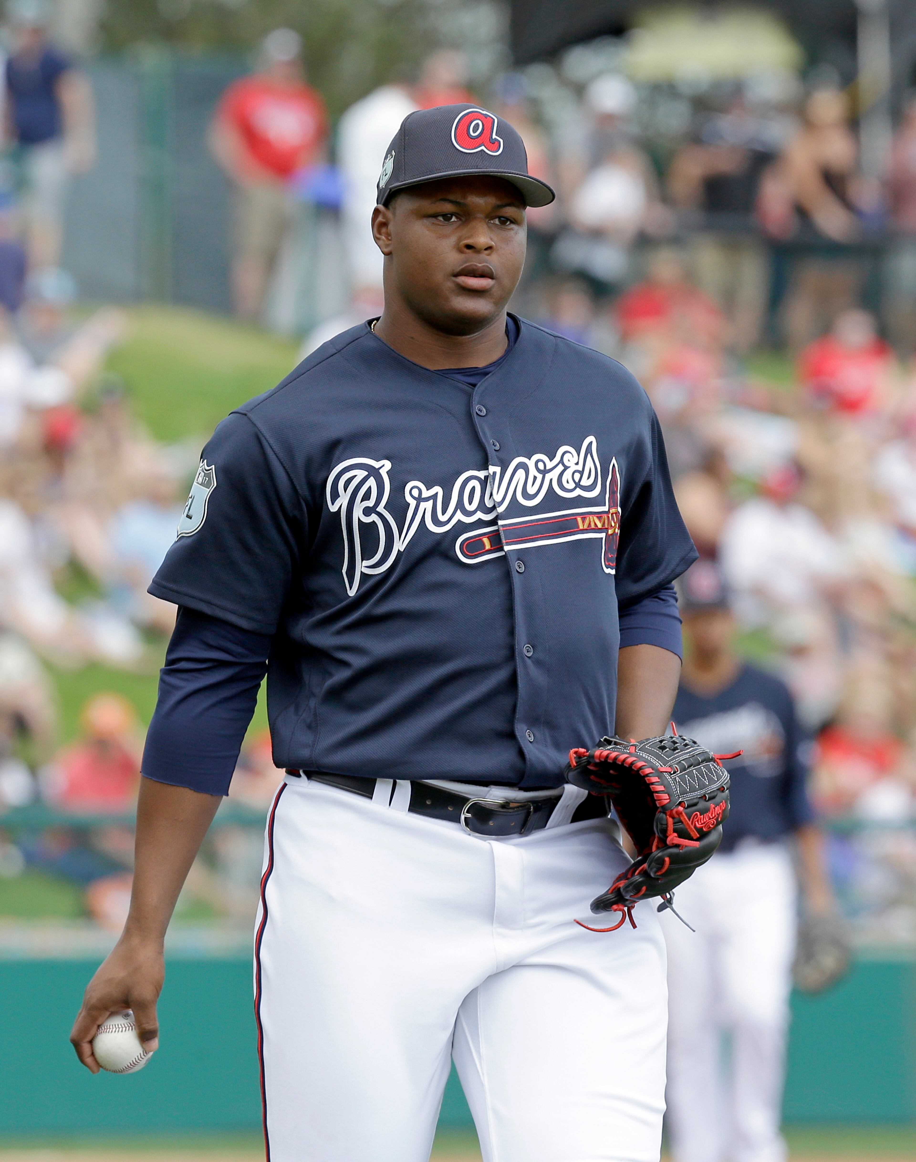 Atlanta Braves relief pitcher Mauricio Cabrera tosses the ball to first to get a Philadelphia Phillies runner out in a spring training baseball game, Wednesday, March 8, 2017, in Kissimmee, Fla. (AP Photo/John Raoux)
