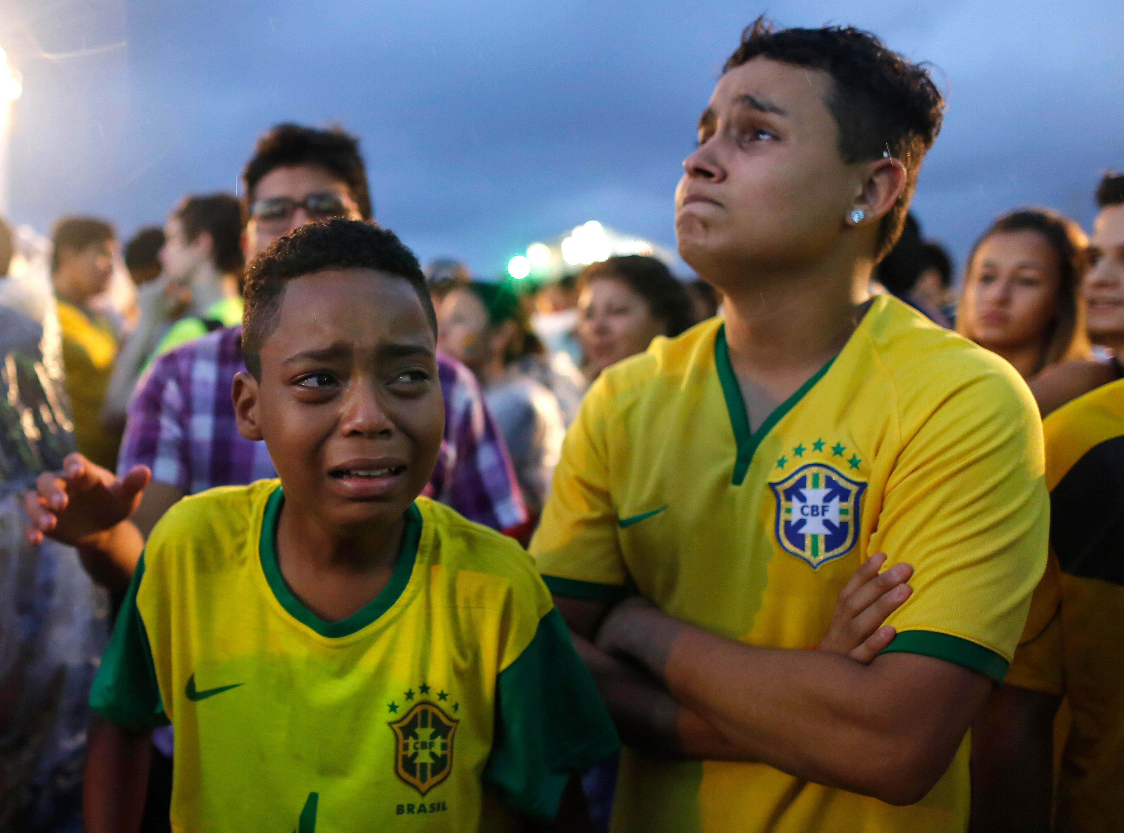 Brazil soccer fans cry as they watch their team get beat during a live telecast of the semifinals World Cup soccer match between Brazil and Germany, inside the FIFA Fan Fest area on Copacabana beach in Rio de Janeiro, Brazil, Tuesday, July 08, 2014. (AP Photo/Leo Correa)