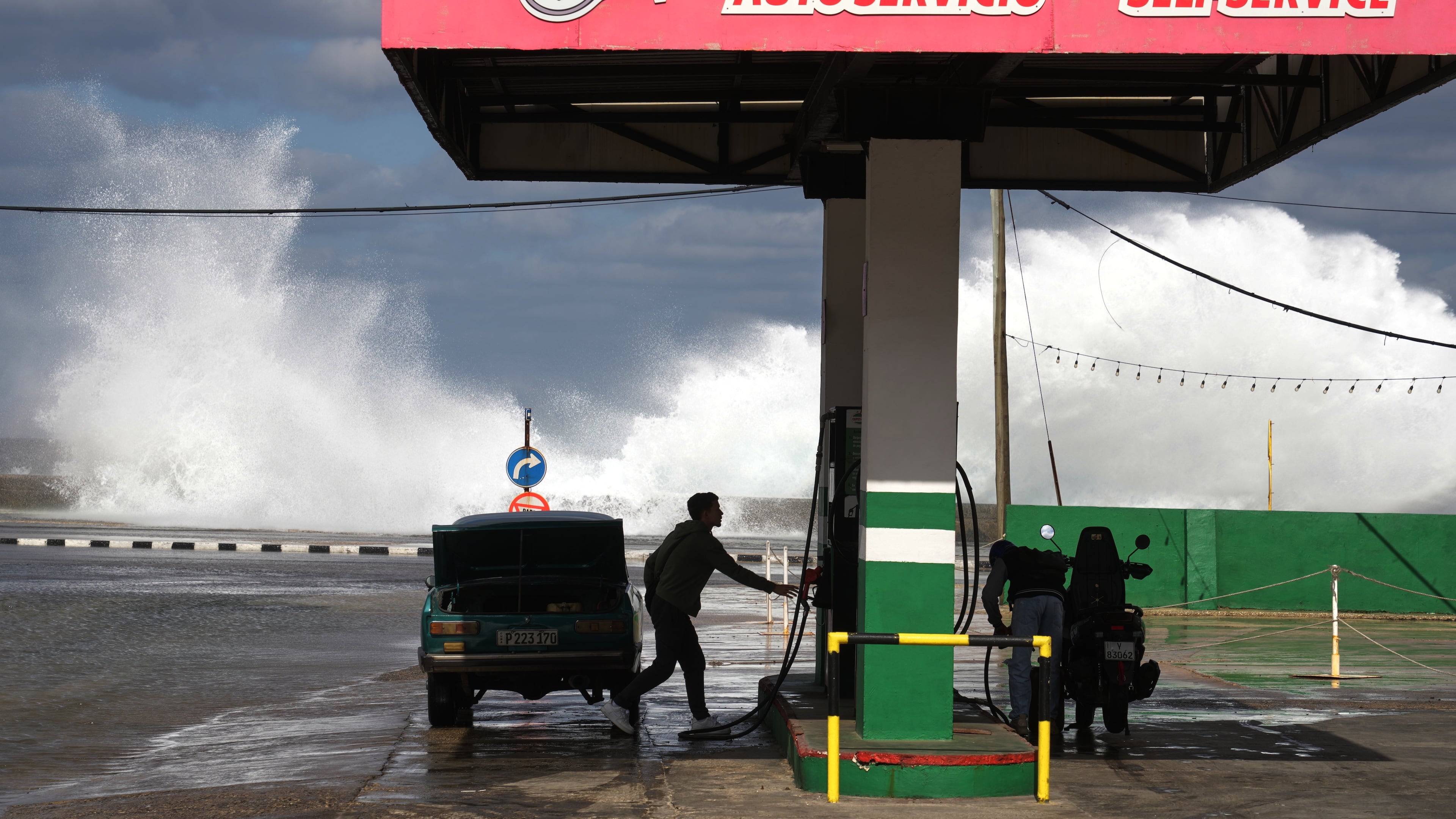People refuel their car and motorcycle at a gas station near the Malecon in Havana, Cuba, Tuesday, Jan. 27, 2026. (AP Photo/Ramon Espinosa)