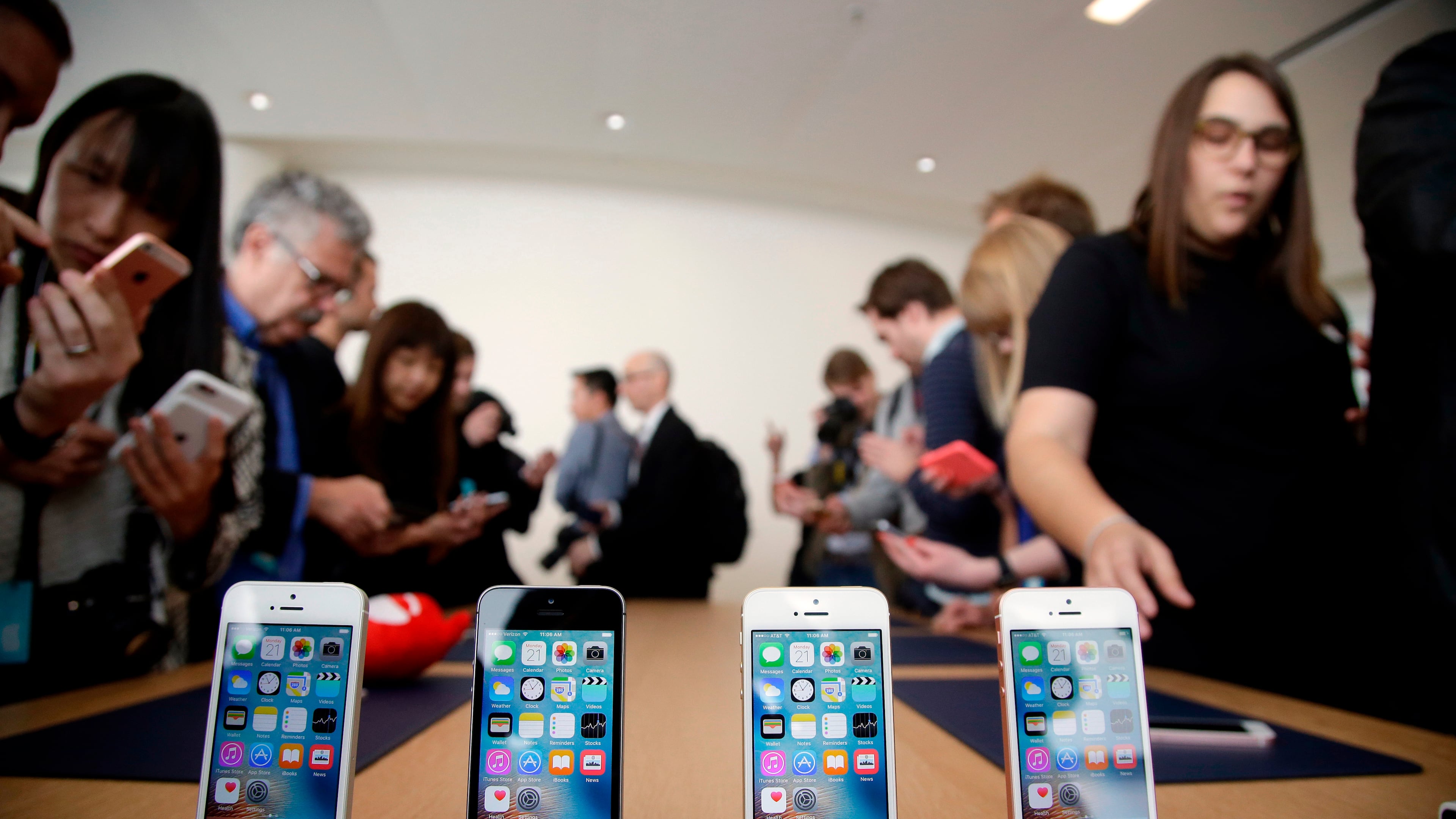 FILE- In this March 21, 2016, file photo members of the media and invited guests take a look at the new iPhone SE during an event at Apple headquarters in Cupertino, Calif. (AP Photo/Marcio Jose Sanchez, file)