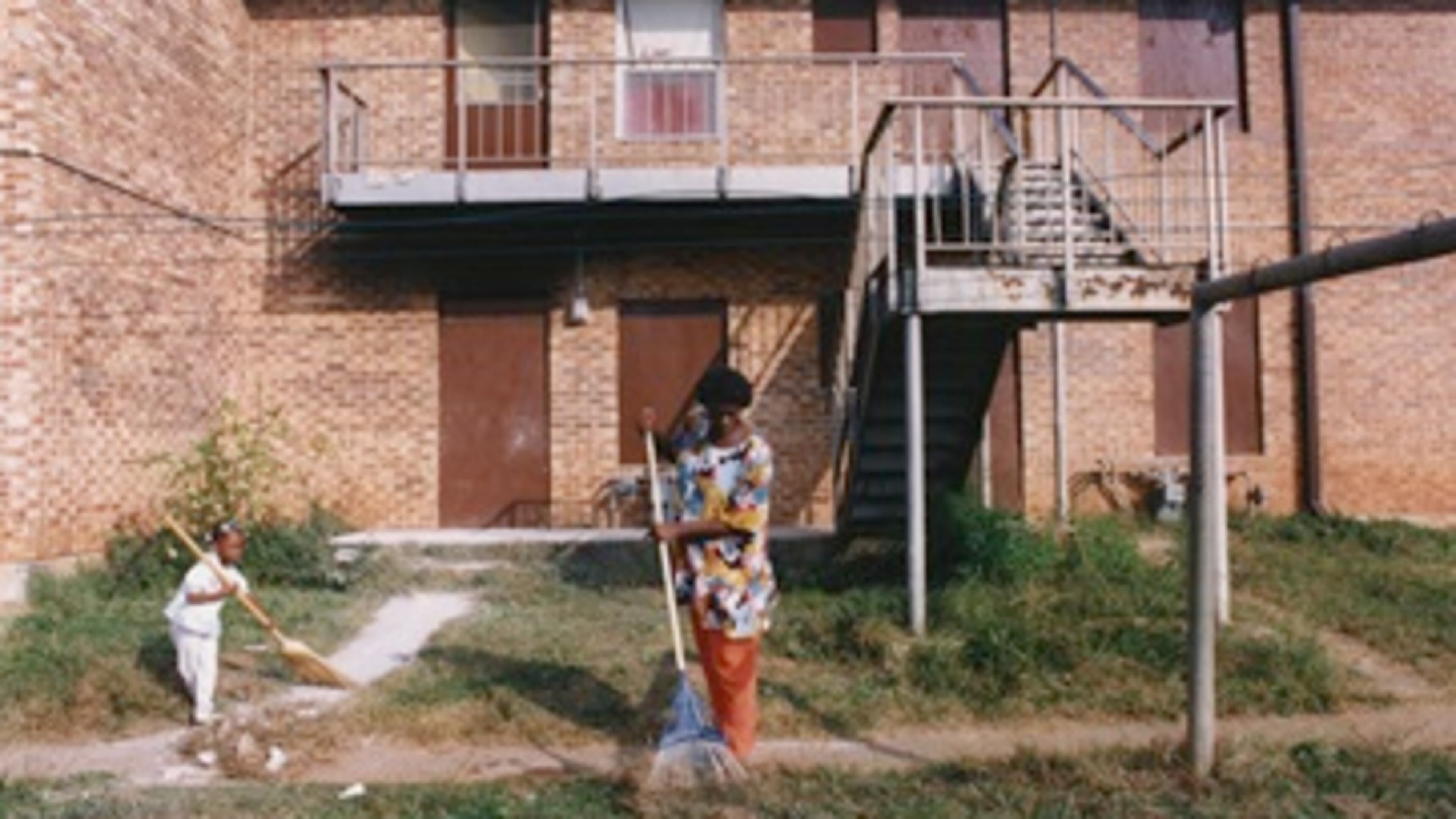 Rilene and Chasity Dixon clean up the lawn in front of their East Lake Meadows apartment. Atlanta, GA. October 28, 1992. (Credit:PBS)