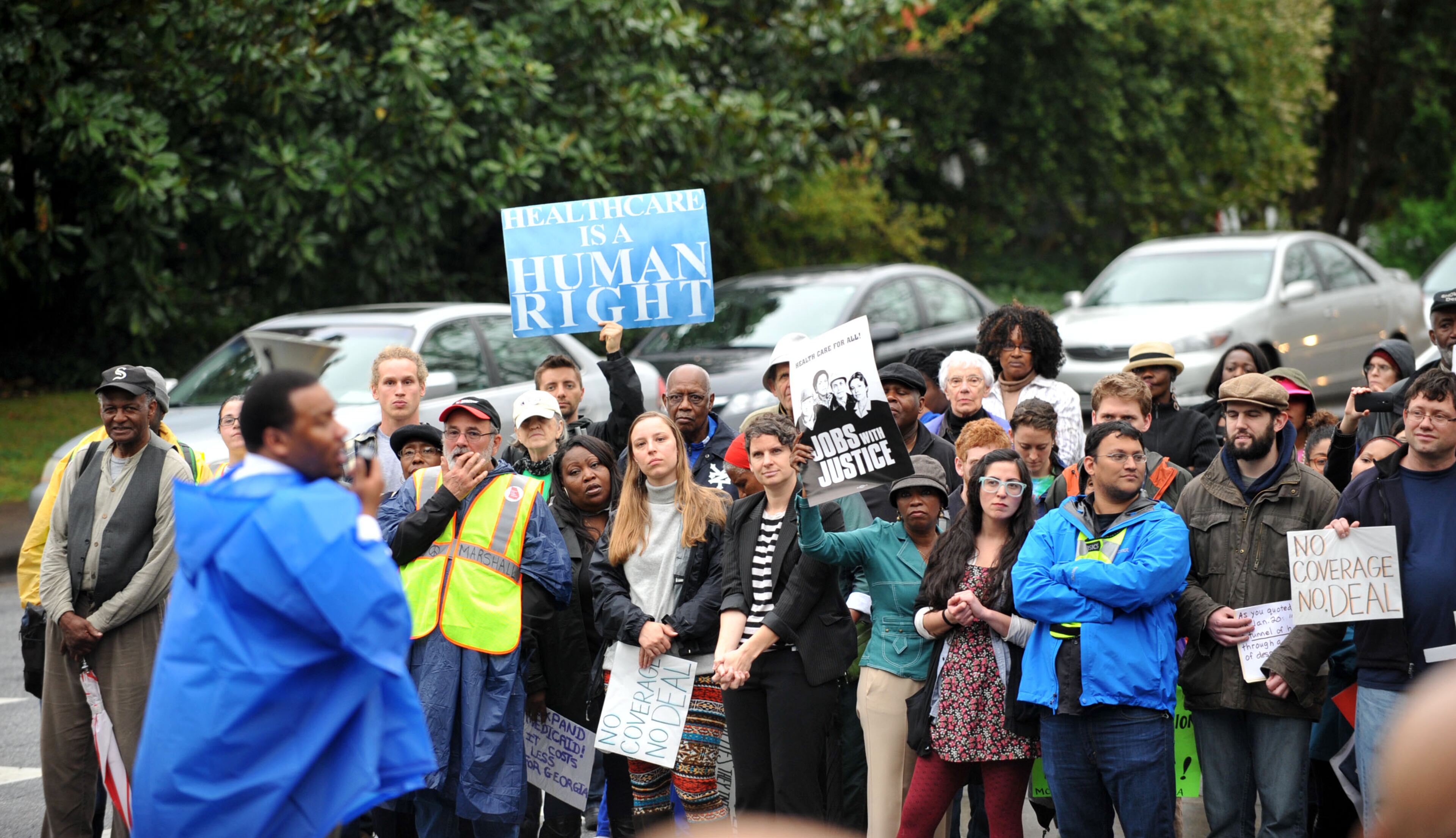 A crowd that swelled to more than 100 demonstrated outside the Governor's Mansion on W. Paces Ferry Road Monday, April 7, 2014. Protesters were calling on Governor Nathan Deal to expand Medicaid services in the state. KENT D. JOHNSON / KDJOHNSON@AJC.COM