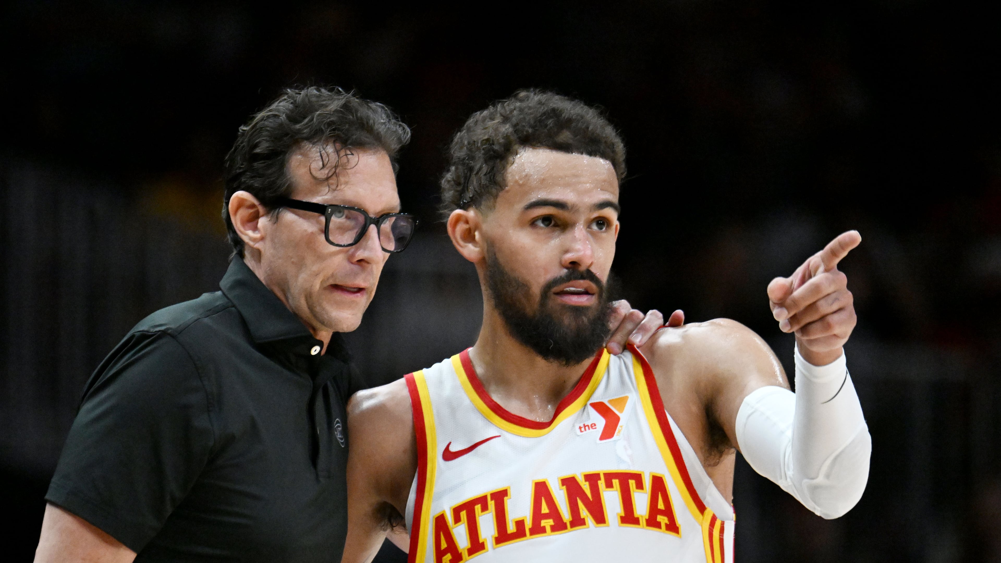 Hawks head coach Quin Snyder (left) and guard Trae Young confer during an NBA basketball game at State Farm Arena on April 1 in Atlanta. Young and Snyder have built a strong relationship since the team hired Snyder in 2023. (Hyosub Shin/AJC)