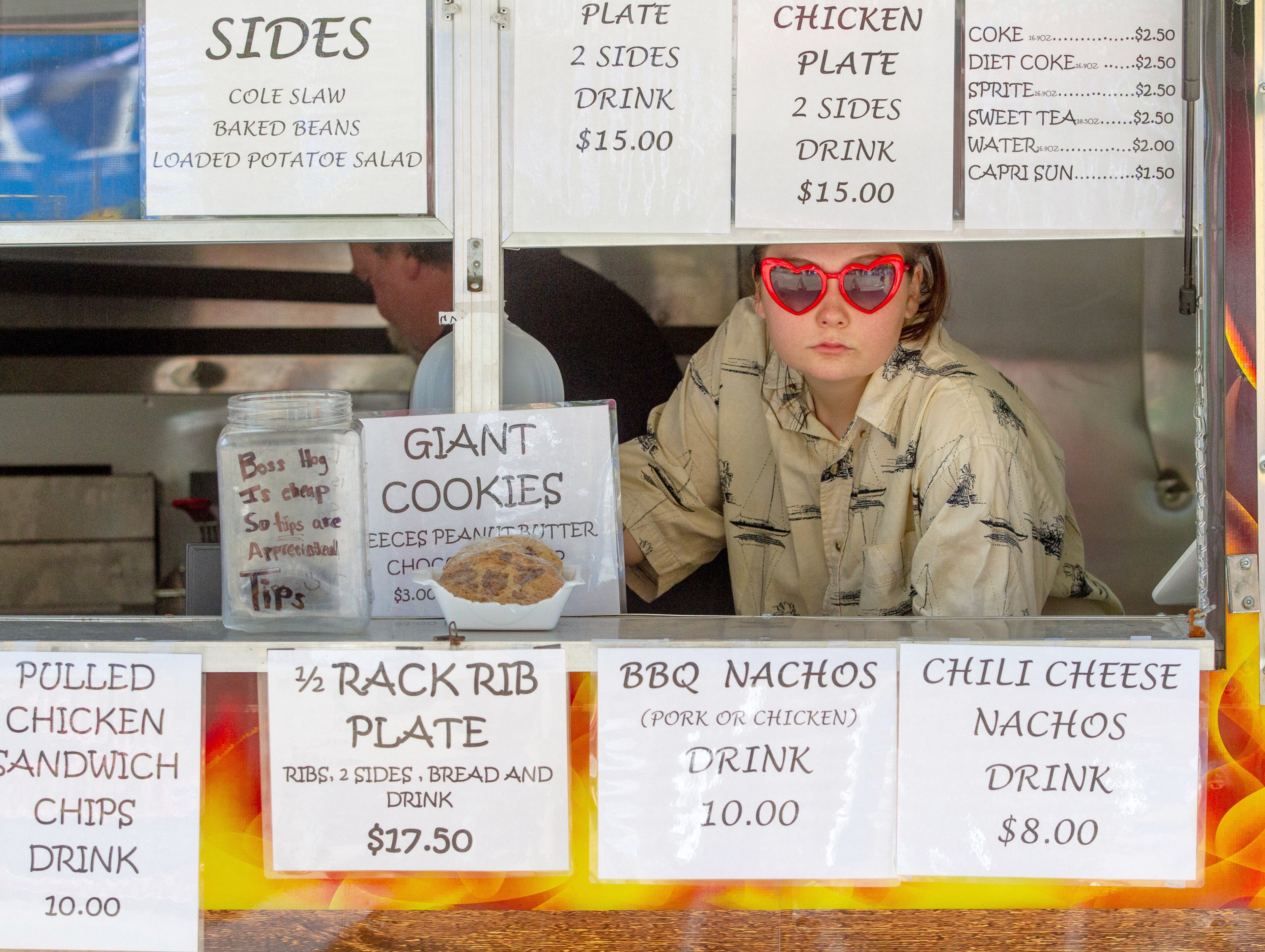 Chaser Haley Morris waits for customers at the Hog N Dog BBQ booth during the 20th annual Lemonade Days Festival on Sunday, April 28, 2019, in Dunwoody. Lemonade Days is the largest annual fundraising event for Dunwoody Preservation Trust. All proceeds are used within the community for historic preservation and education. STEVE SCHAEFER / SPECIAL TO THE AJC