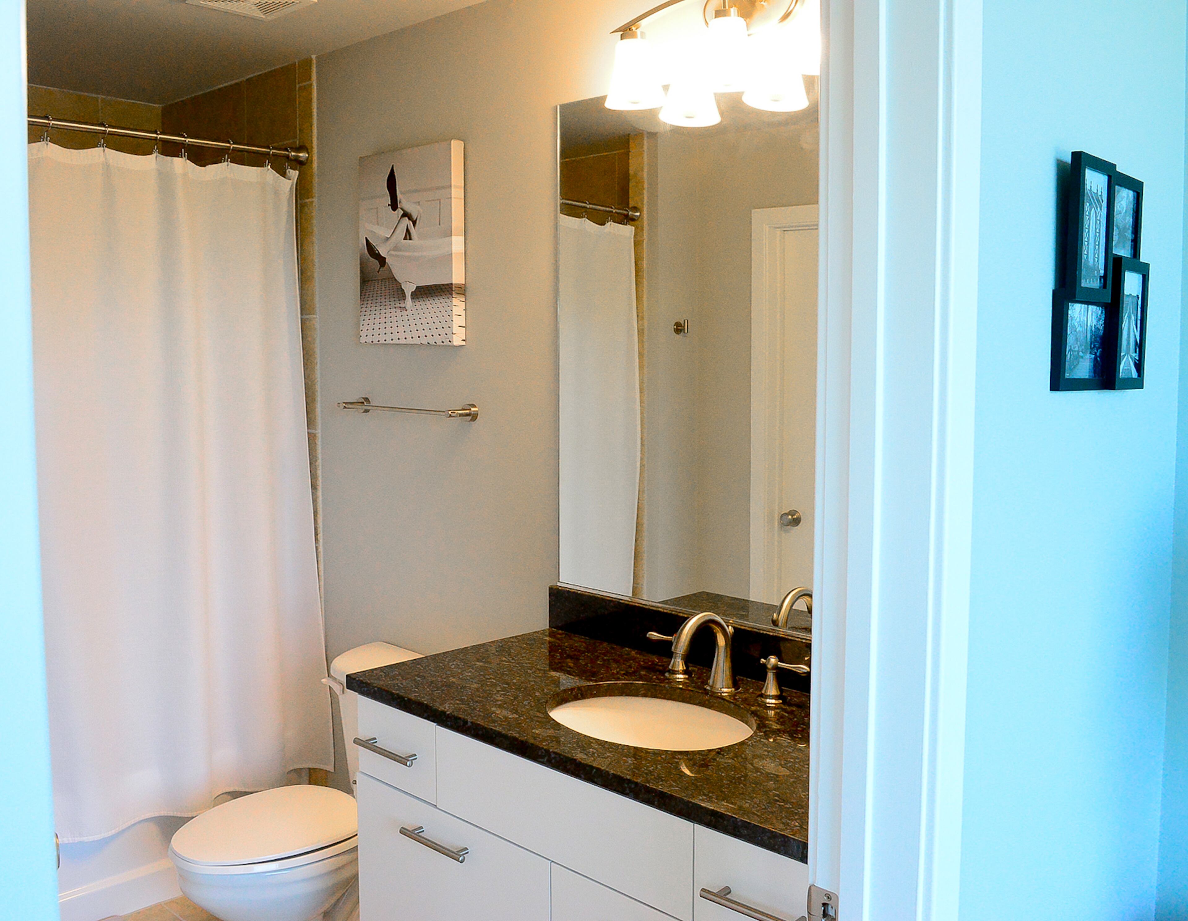 So far, Jason Raymond has updated the wall color, choosing a platinum gray, and the cabinets, which were resanded and repainted white, in the guest bathroom.
