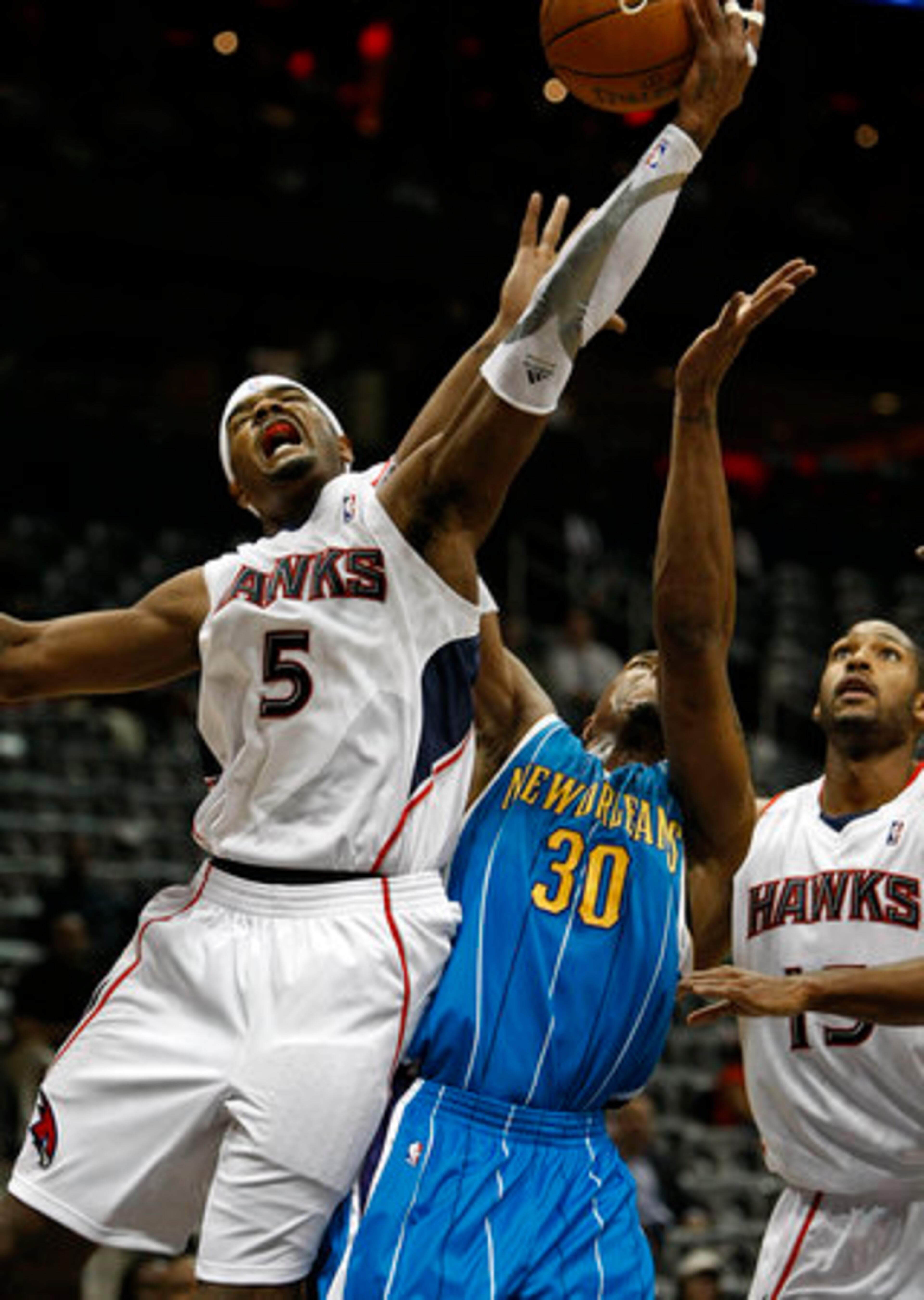 Hawks forward # 5 Josh Smith goes over New Orleans Hornets forward # 30 David West for a rebound