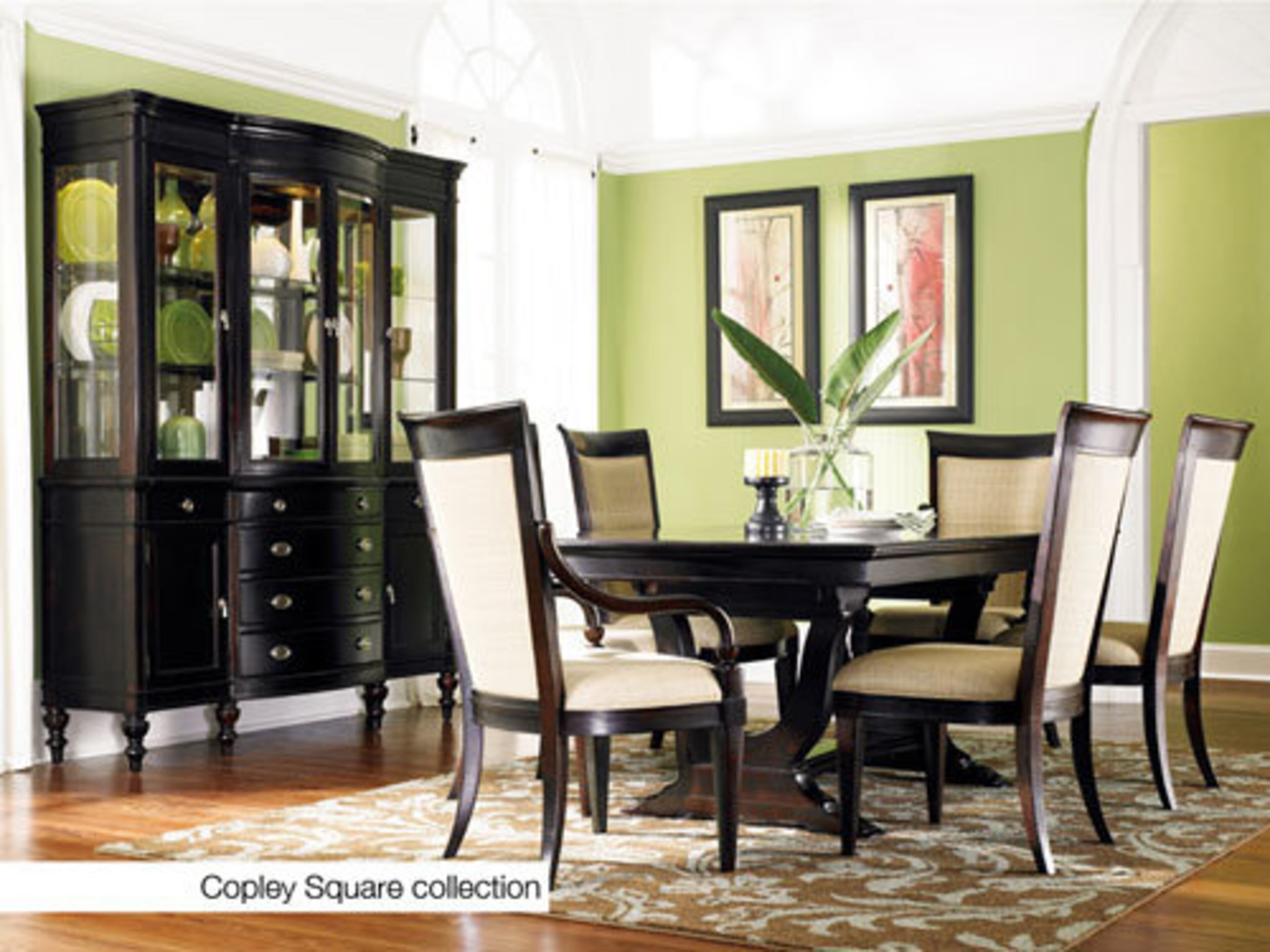 Crisp color puts a fresh twist on formal dining while showcasing classic curves. Green plates and vases in the china cabinet add interest, accented by a touch of red on the wall for intrigue.