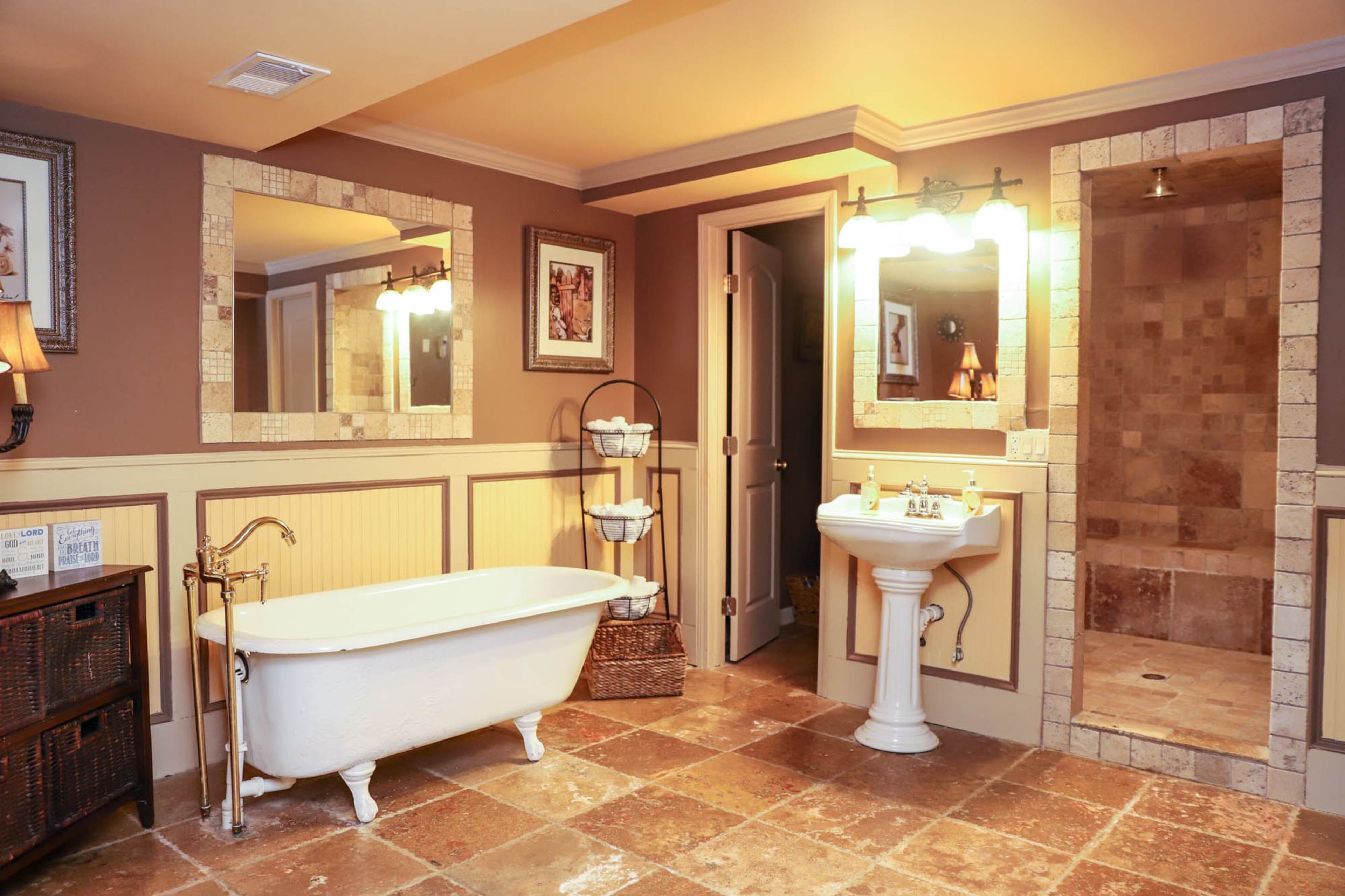 The bathroom in Nadine Faison’s basement has beautiful stone tile and a luxurious clawfoot tub. Faison recently finished the basement renovations, including working with Dina Benoit to paint the space. Text by Shannon Dominy. Photo by Reynolds Rogers.