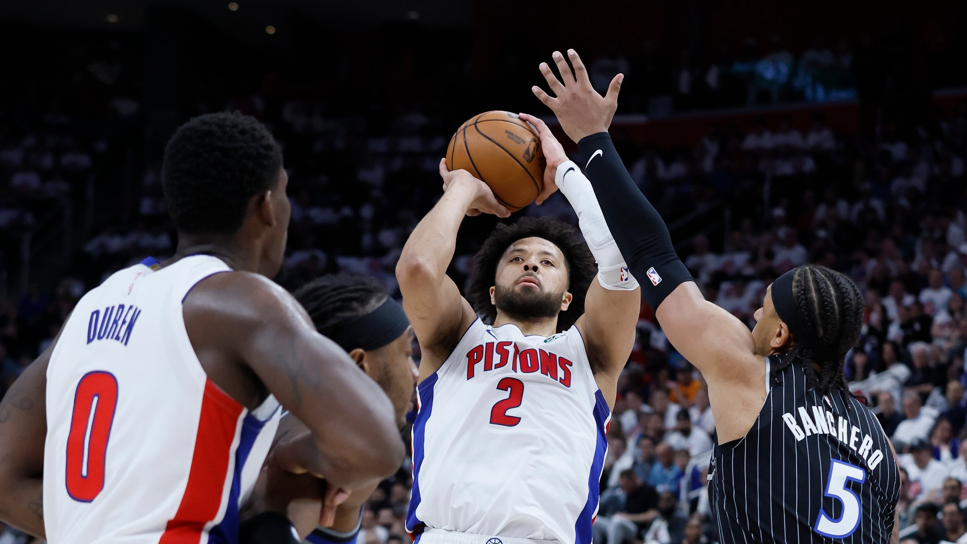 Detroit Pistons guard Cade Cunningham (2) takes a shot against Orlando Magic forward Paolo Banchero (5) as Pistons center Jalen Duren (0) helps defend during the first half in Game 2 of a first-round NBA basketball playoffs series Wednesday, April 22, 2026, in Detroit. (AP Photo/Duane Burleson)