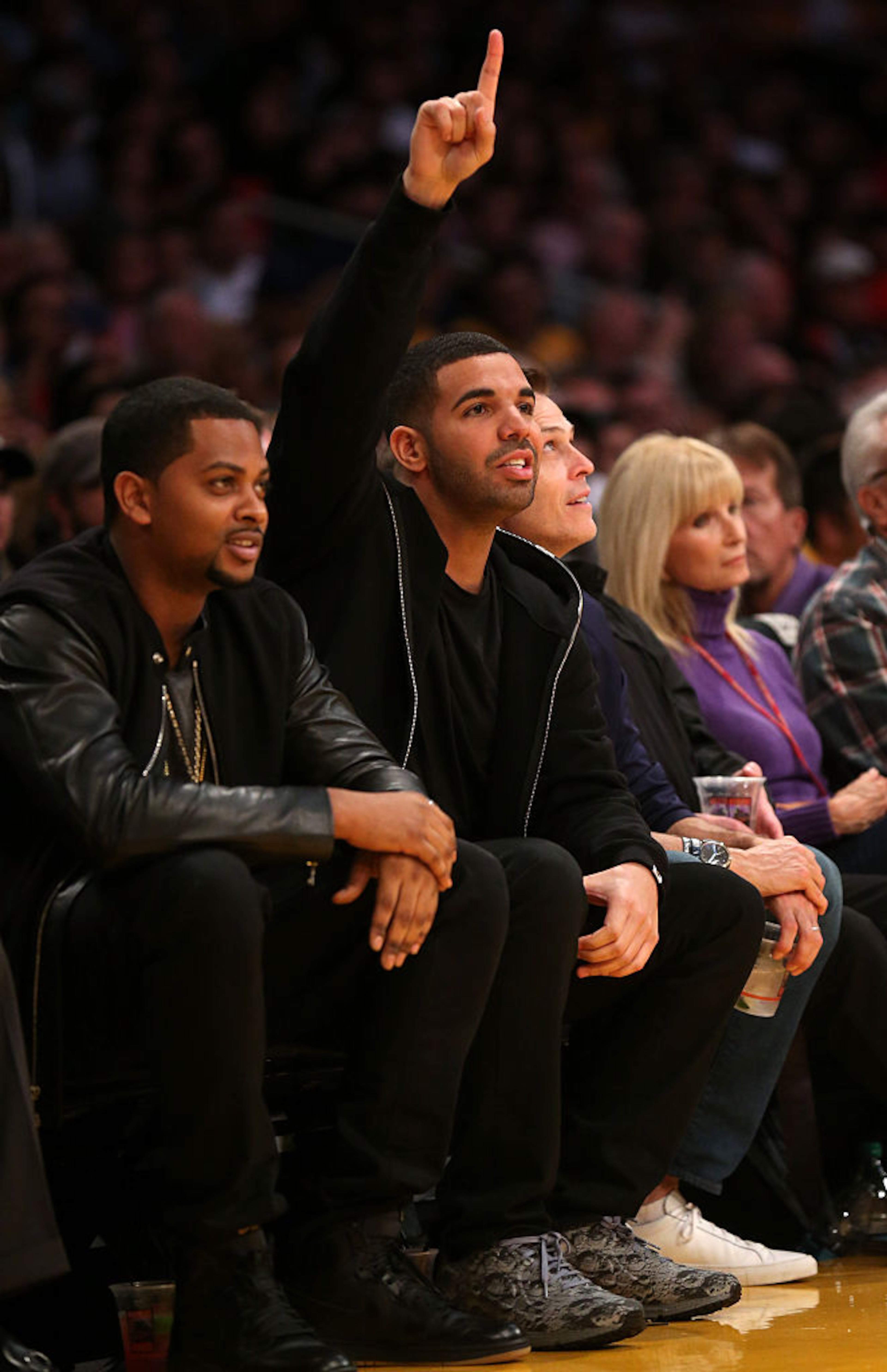 LOS ANGELES, CA - NOVEMBER 30: Rapper and Toronto Raptors team ambassador Drake holds up a finger as a Raptor takes a foul shot against the Los Angeles Lakers at Staples Center on November 30, 2014 in Los Angeles, California. The Lakers 129-122 in overtime. NOTE TO USER: User expressly acknowledges and agrees that, by downloading and or using this photograph, User is consenting to the terms and conditions of the Getty Images License Agreement. (Photo by Stephen Dunn/Getty Images)