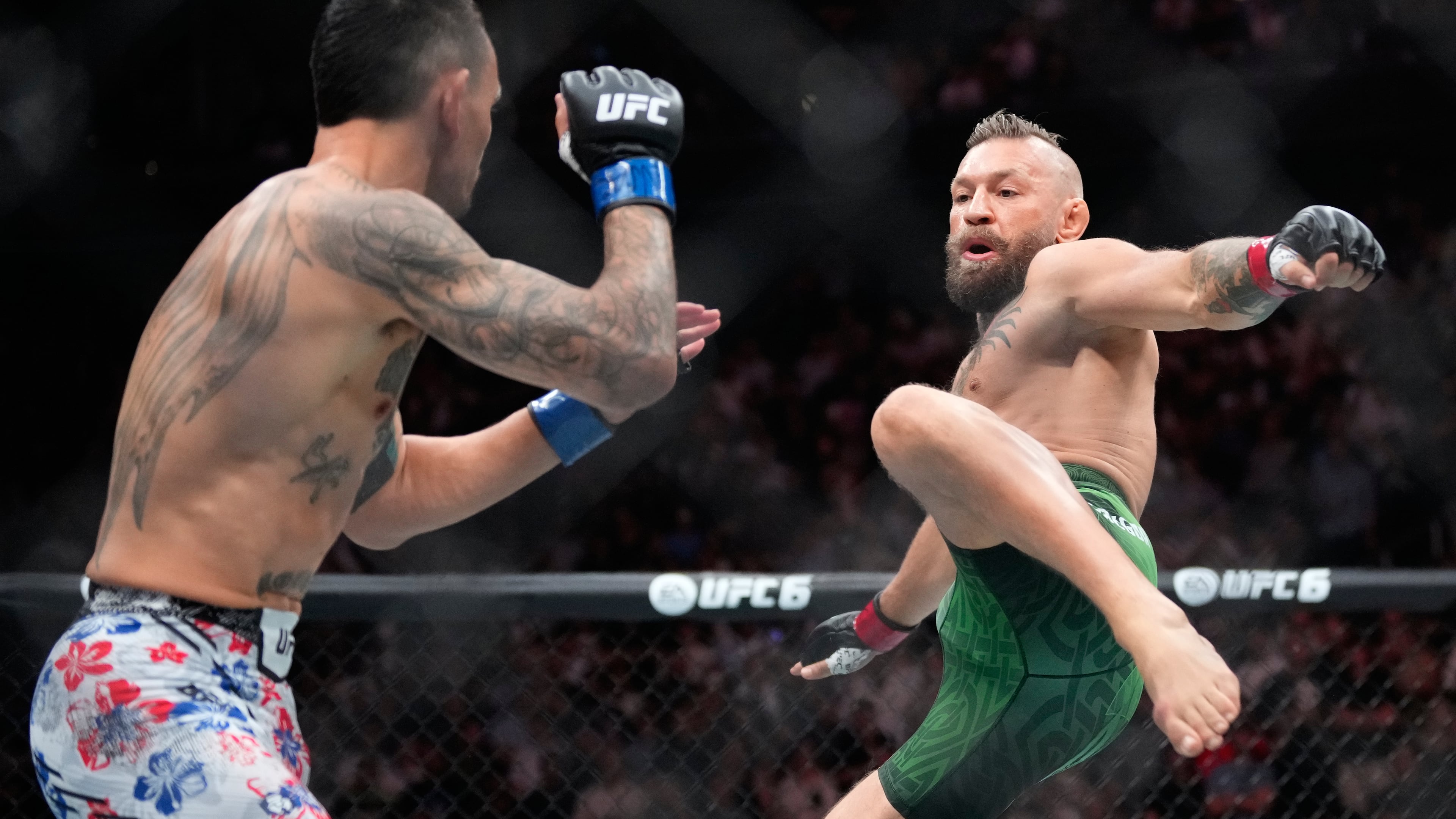 Conor McGregor, right, jumps into the air for a kick as he fights Max Holloway in a welterweight fight at the UFC 329 mixed martial arts event Saturday, July 11, 2026, in Las Vegas. (AP Photo/John Locher)