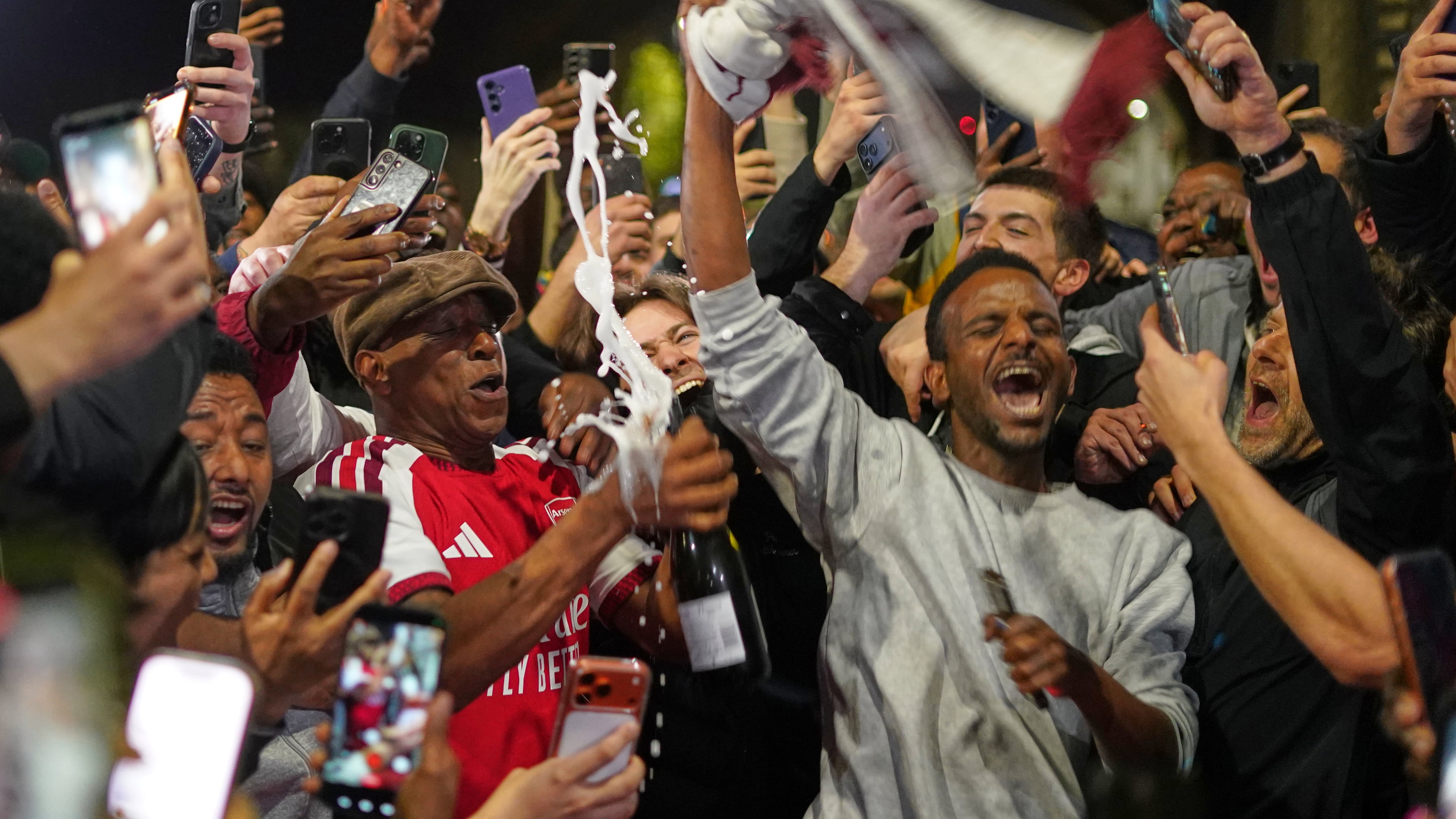 Former Arsenal player Ian Wright celebrates with Arsenal supporters at the Arsenal stadium after Arsenal's soccer team won the Premier League title in London, Tuesday, May 19, 2026.(AP Photo/Alberto Pezzali)