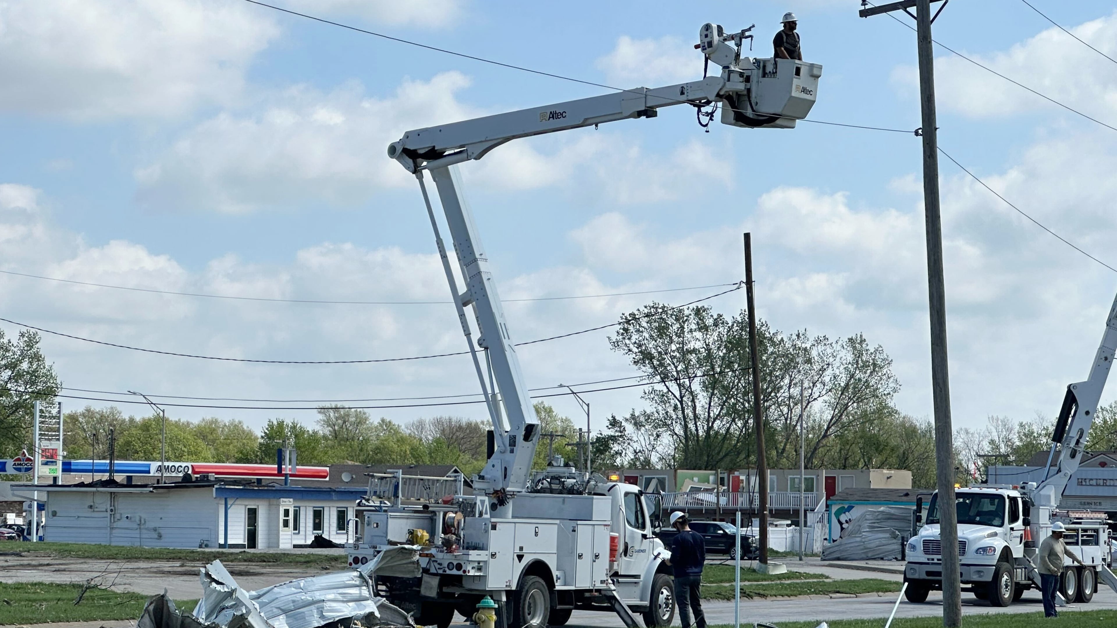 Crews work on power lines in Ottawa, Kansas, on Tuesday, April 14, 2026, following severe storms. (AP Photo/Nick Ingram)