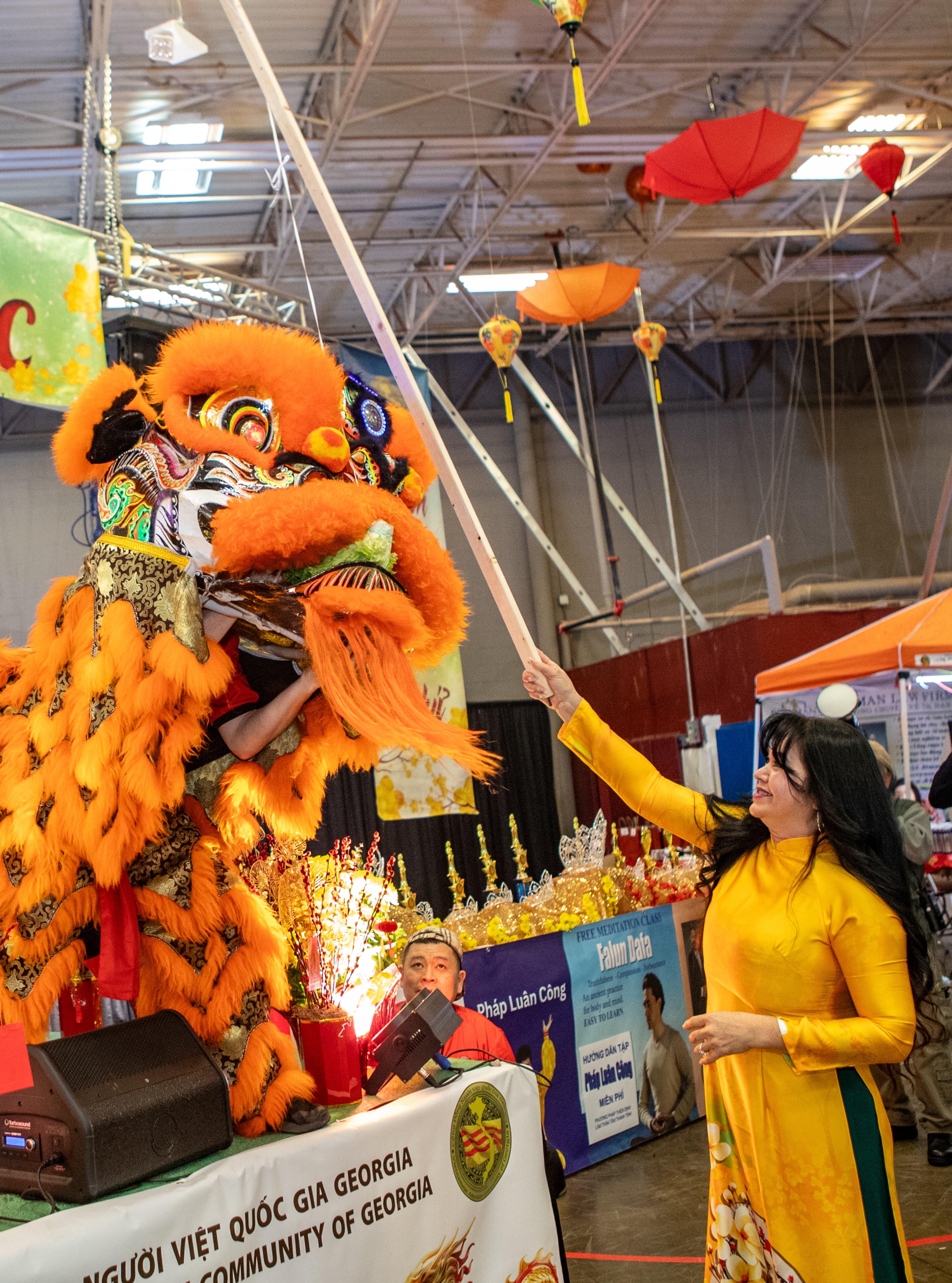 During the lion dance performance, Linda Nguyen, vice president of The Vietnamese American Community of Georgia feeds the lion during the Lunar New Year celebration at Plaza Las Americas in Lilburn on Saturday, Feb 3, 2024 where dragon and lion dancing begins the weekend. The celebration continues on Sunday and includes traditional food, music and cultural festivities. (Jenni Girtman for The Atlanta Journal-Constitution)