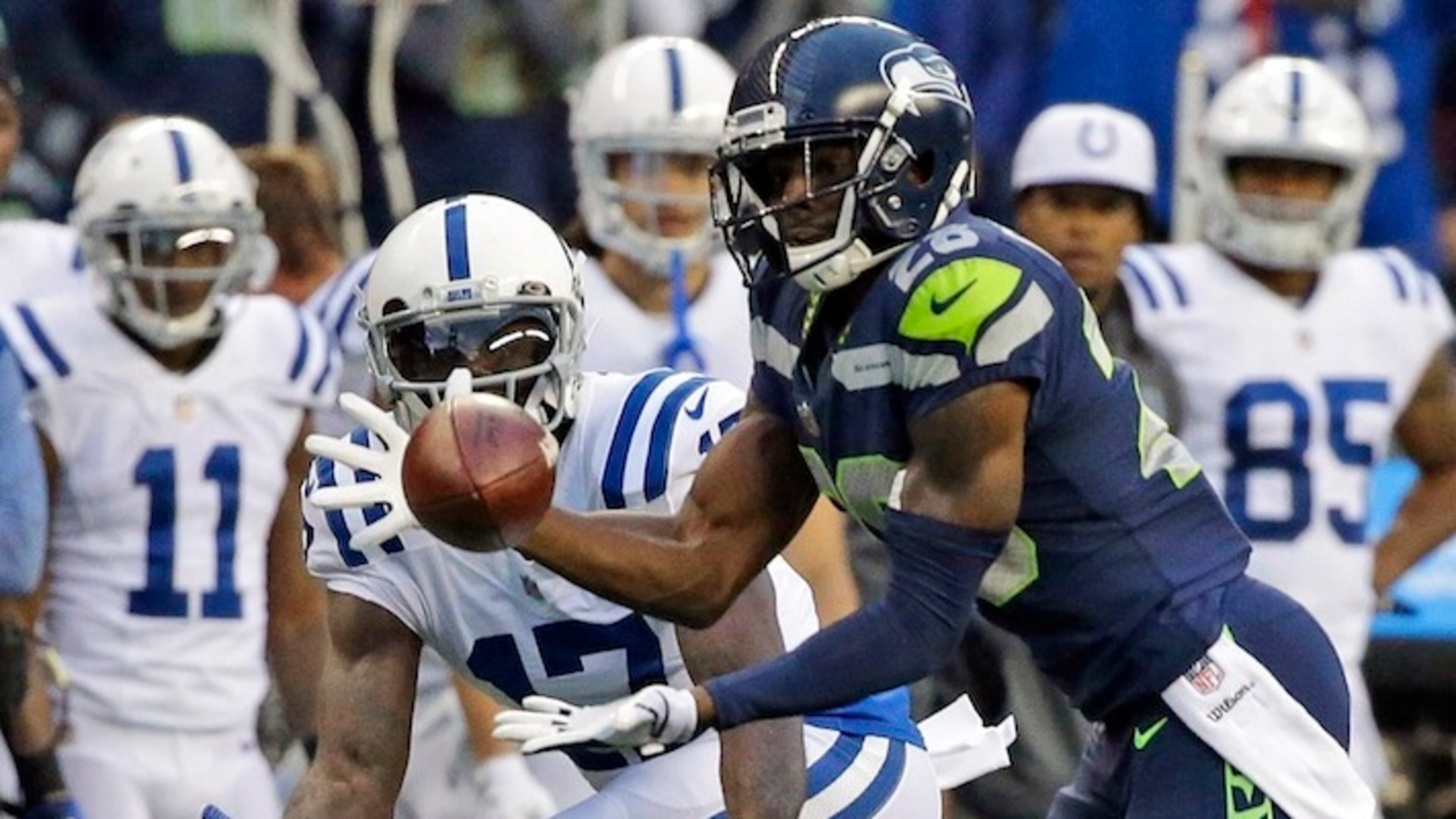Seattle Seahawks cornerback Justin Coleman, right, intercepts a pass intended for Indianapolis Colts wide receiver Kamar Aiken, center, in the first half of an NFL football game, Sunday, Oct. 1, 2017, in Seattle. Coleman returned the pick for a touchdown. (AP Photo/Elaine Thompson)