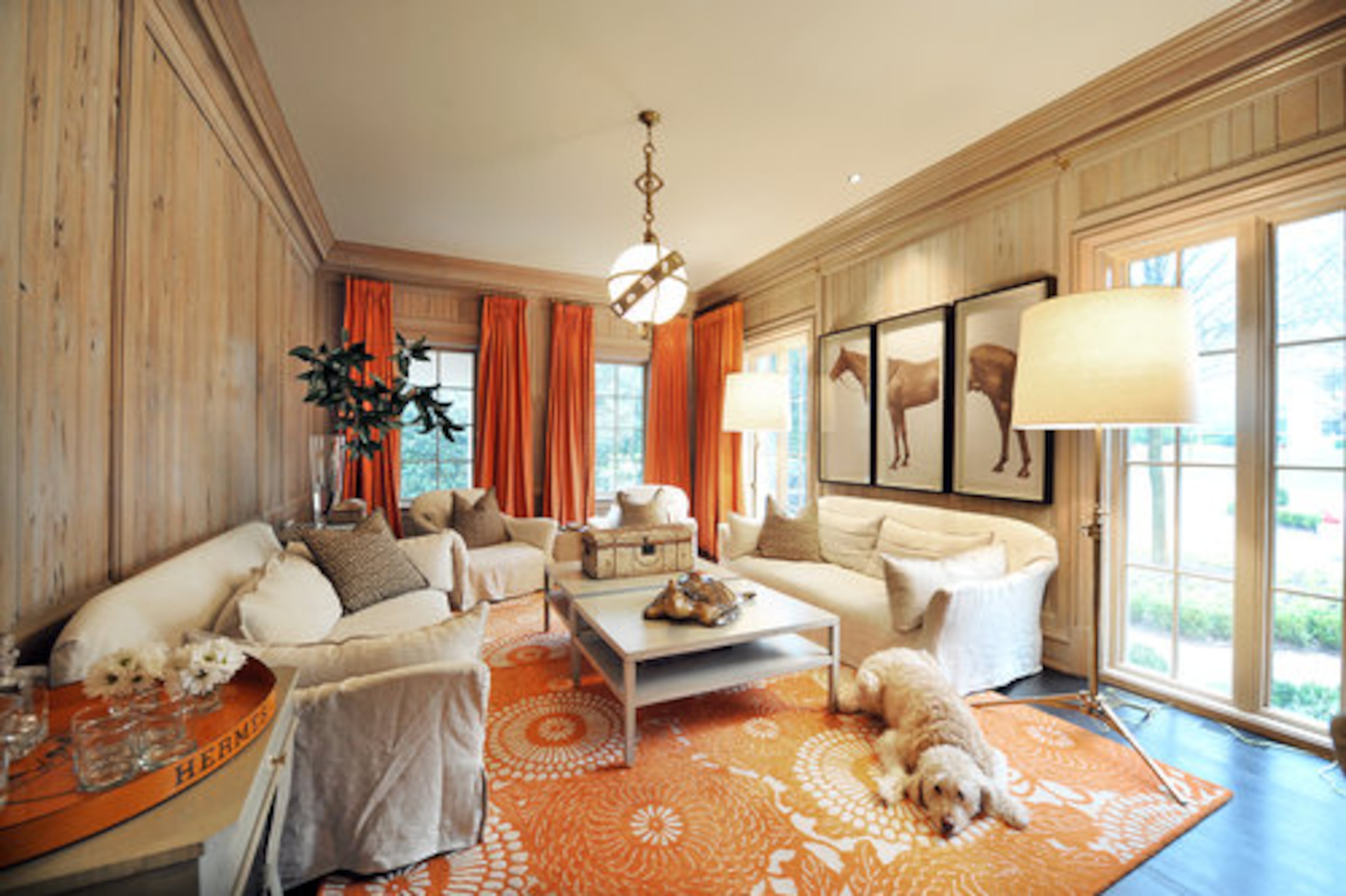 One of Melanie's favorite rooms is the library, which "pays homage to 1970s Hermes," she says. The look started with the tray and the horse painting. It was fulfilled with Pecky Cypress walls, brass and gold accessories and a Pottery Barn rug. "I love orange," she says. Their dog Jesse seems to like it, too.