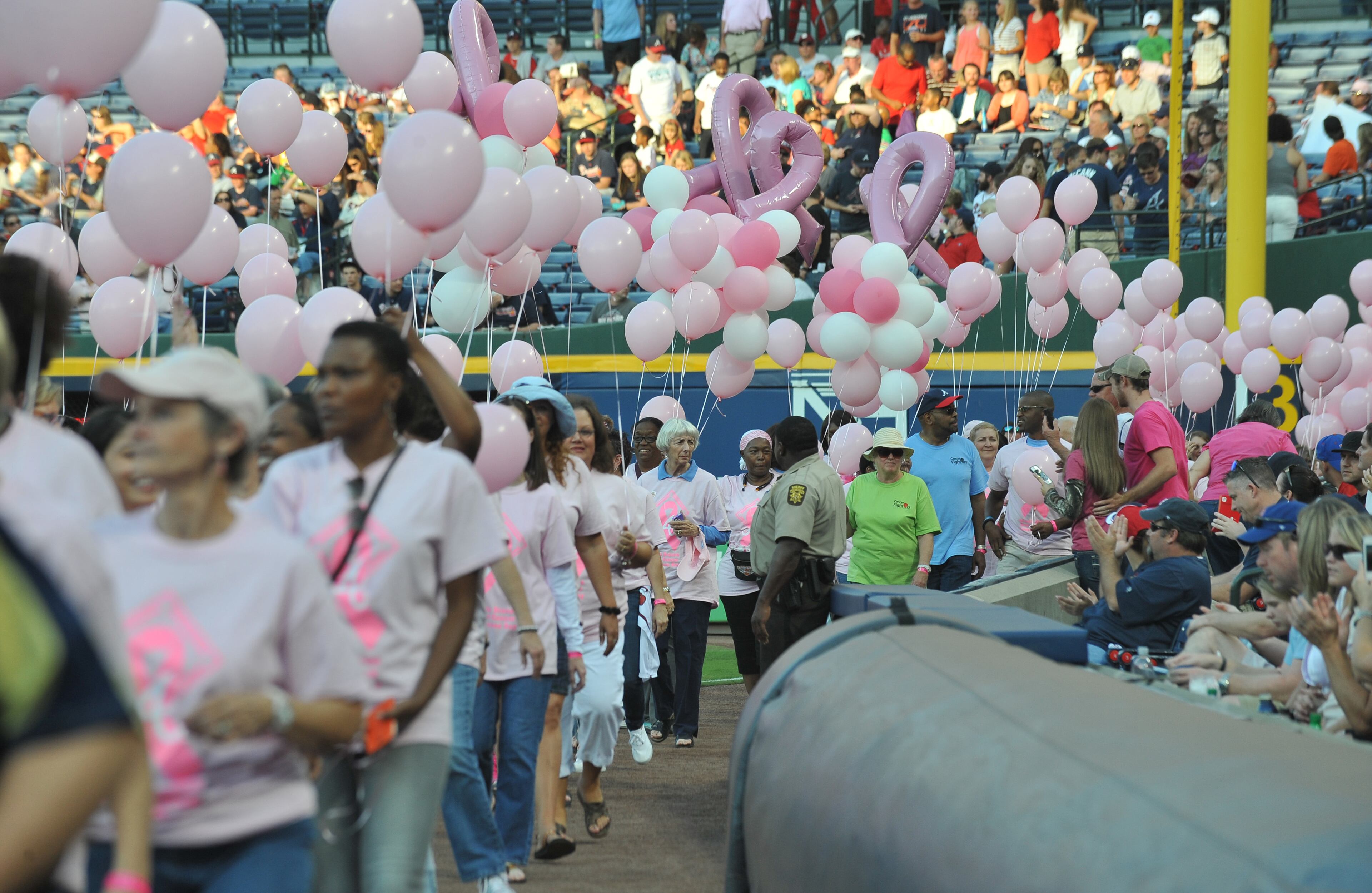 About 300 survivors and their families marched on field during "A Walk in the Park," a pregame ceremony before Atlanta Braves game against the San Diego Padres at Turner Field on Saturday, September 14, 2013. This season, the Braves, WellStar Health System, Kroger and the American Cancer Society Making Strides Against Breast Cancer teamed up for the 7th annual Braves Breast Cancer Awareness Day. The day-long celebration of survivorship honors those who have courageously battled breast cancer, and raised awareness and funds to support research, education and advocacy for cancer patients and their families throughout metro Atlanta.