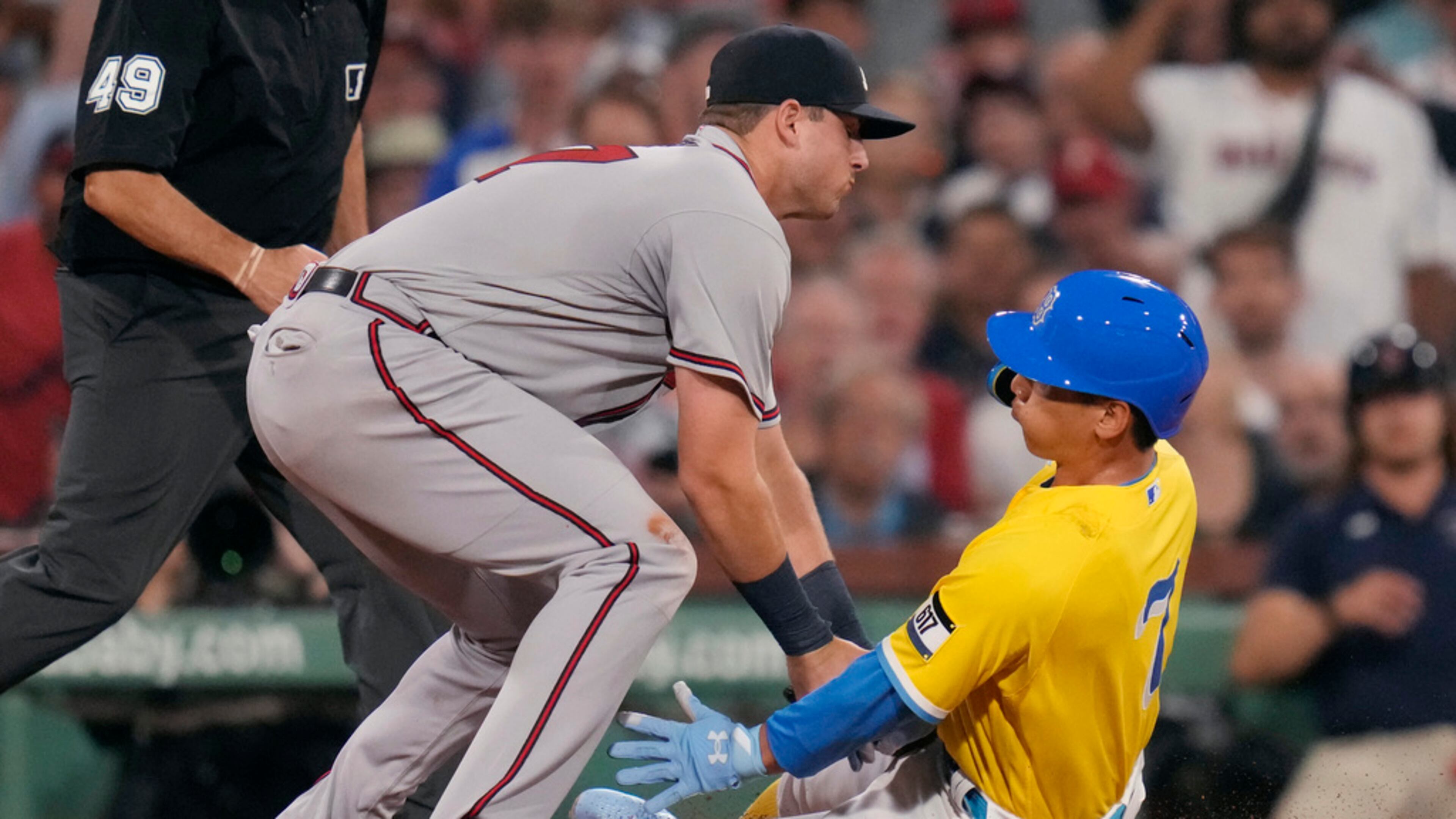 Atlanta Braves third baseman Austin Riley, left, tags out Boston Red Sox's Masataka Yoshida for the third out of a triple play during the third inning of a baseball game at Fenway Park, Tuesday, July 25, 2023, in Boston. (AP Photo/Charles Krupa)