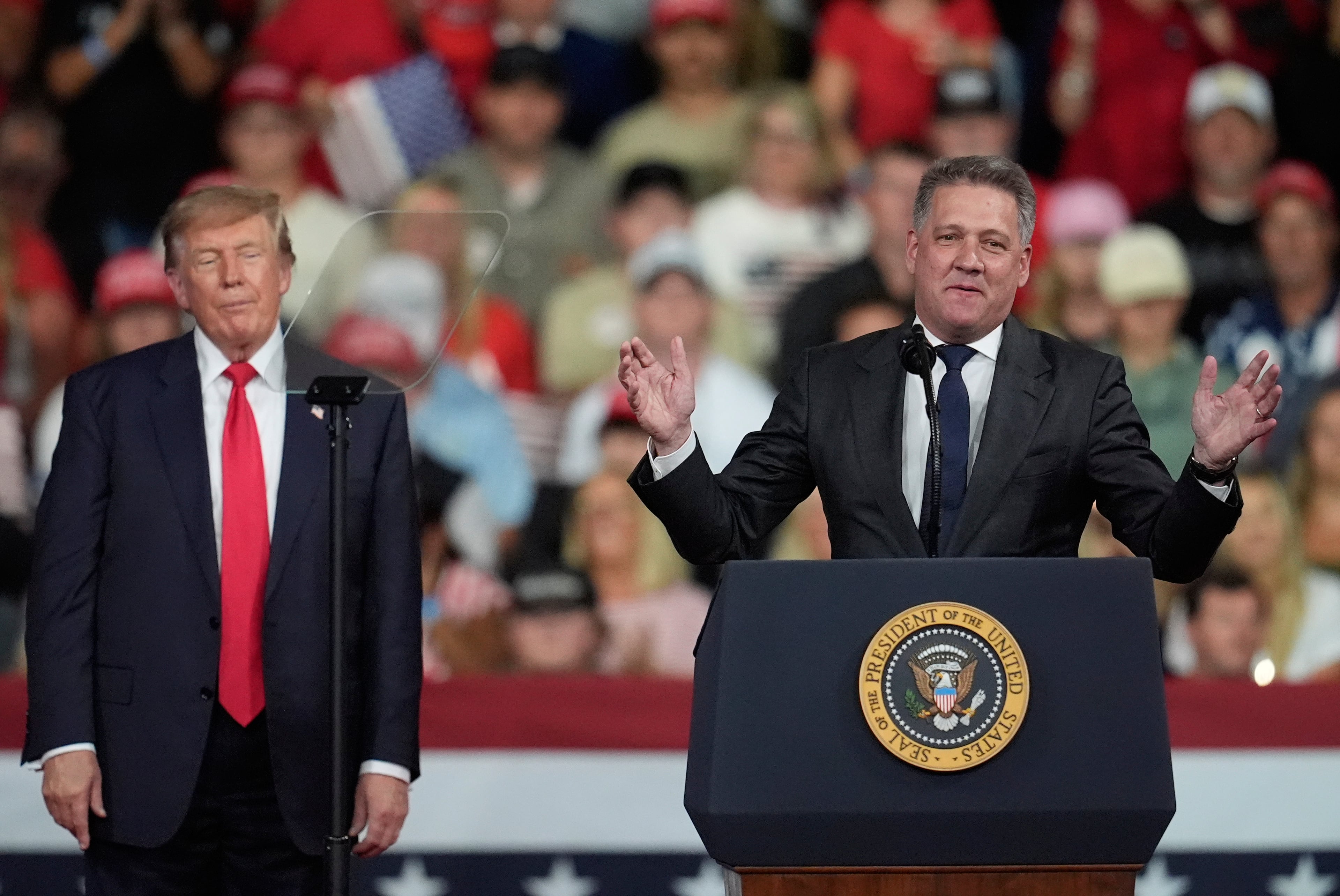 President Donald Trump listens as Gernot Döllner, CEO of Audi AG, speaks at a campaign rally at Guardian Centers of Georgia, Saturday, Oct. 24, 2026, in Perry. (Mike Stewart/AP)