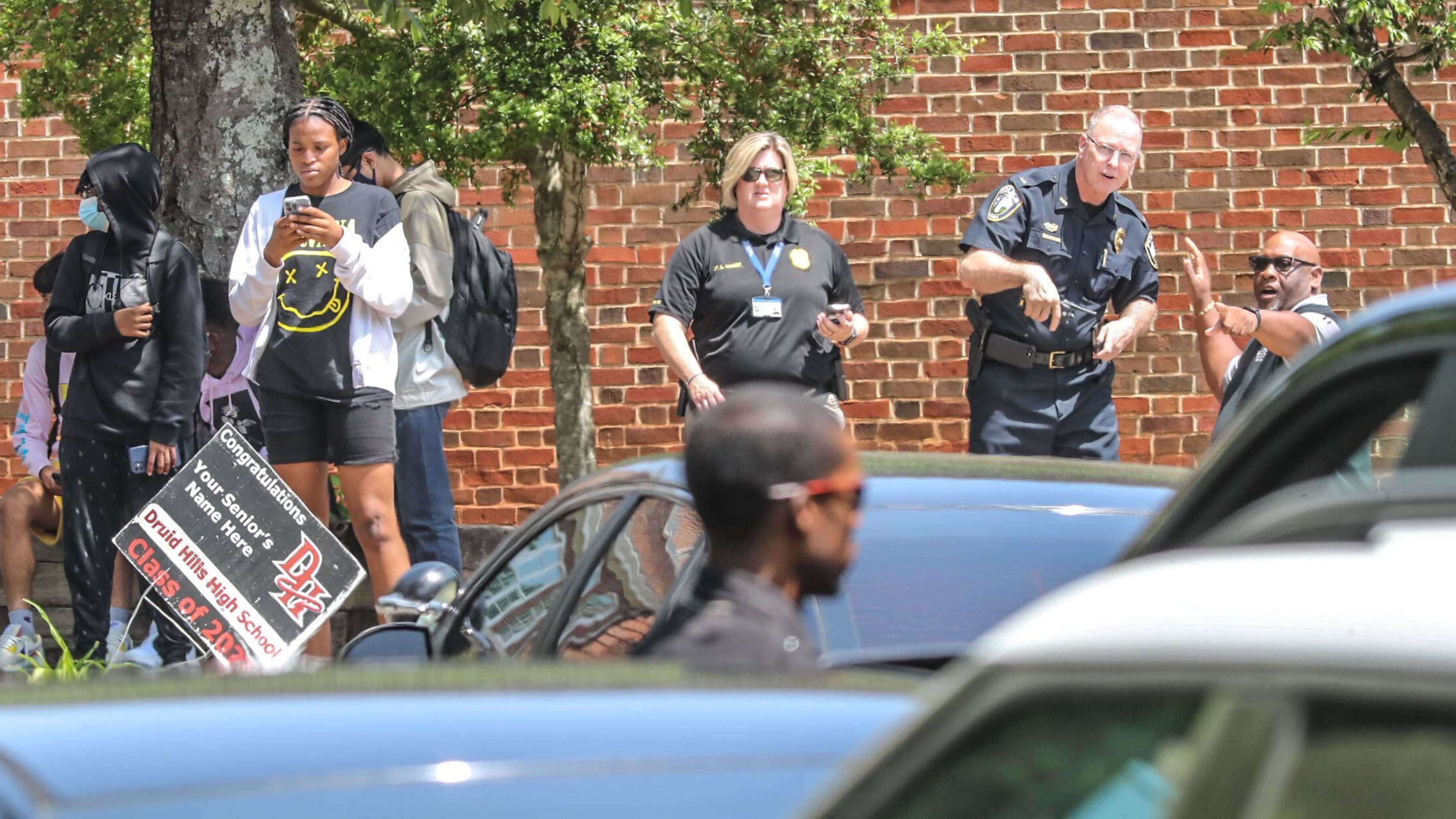 Police officials gather outside of Druid Hills High School after an armed suspect was reported in the area Thursday morning. The suspect, a student at the school, was arrested just before 4 p.m.