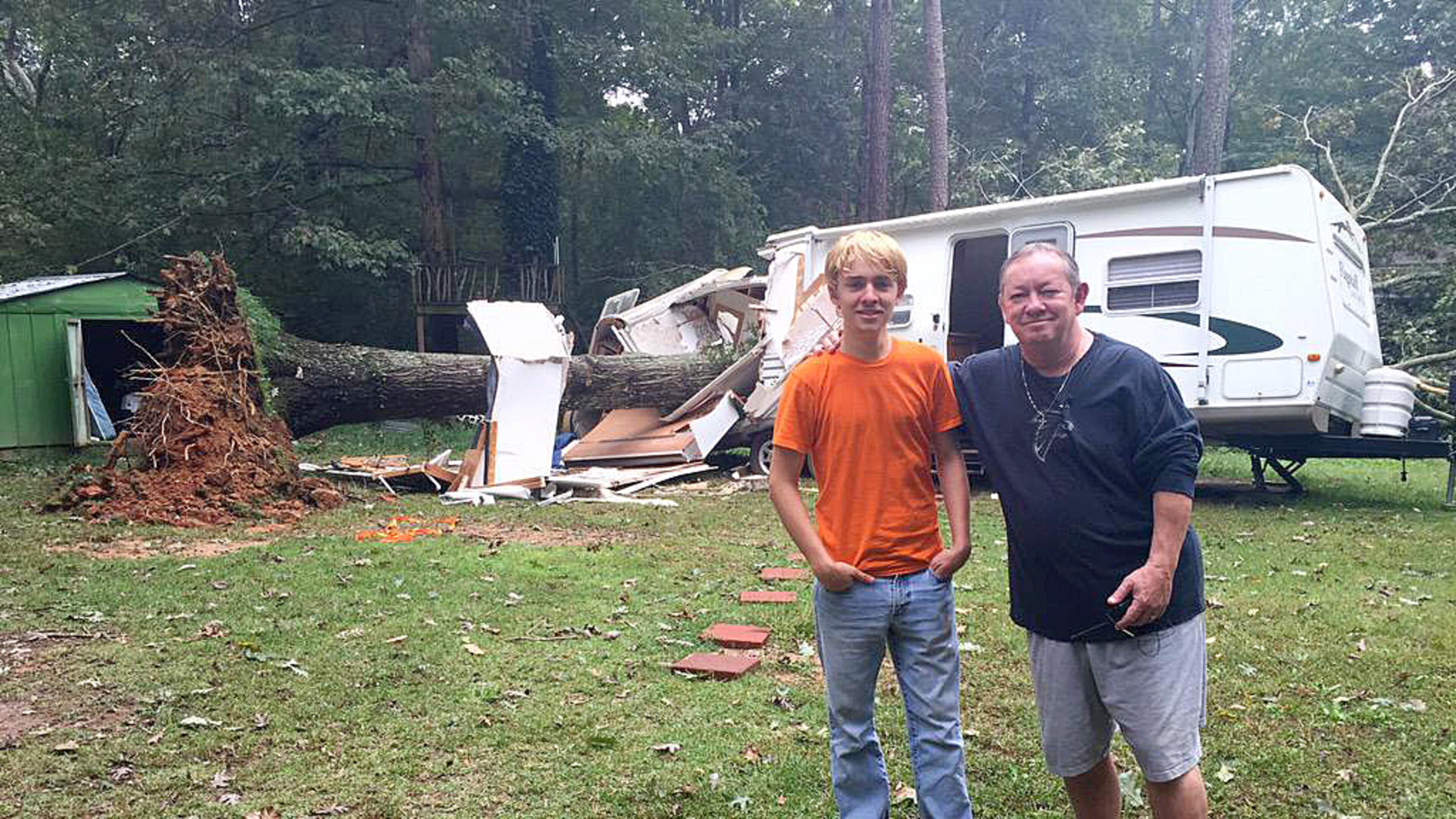 Mac Hubbard, right, pulled his 18-year-old son, Jonn, out of a camper Sunday morning after a tree fell on top of it. (Photo: Channel 2 Action News)