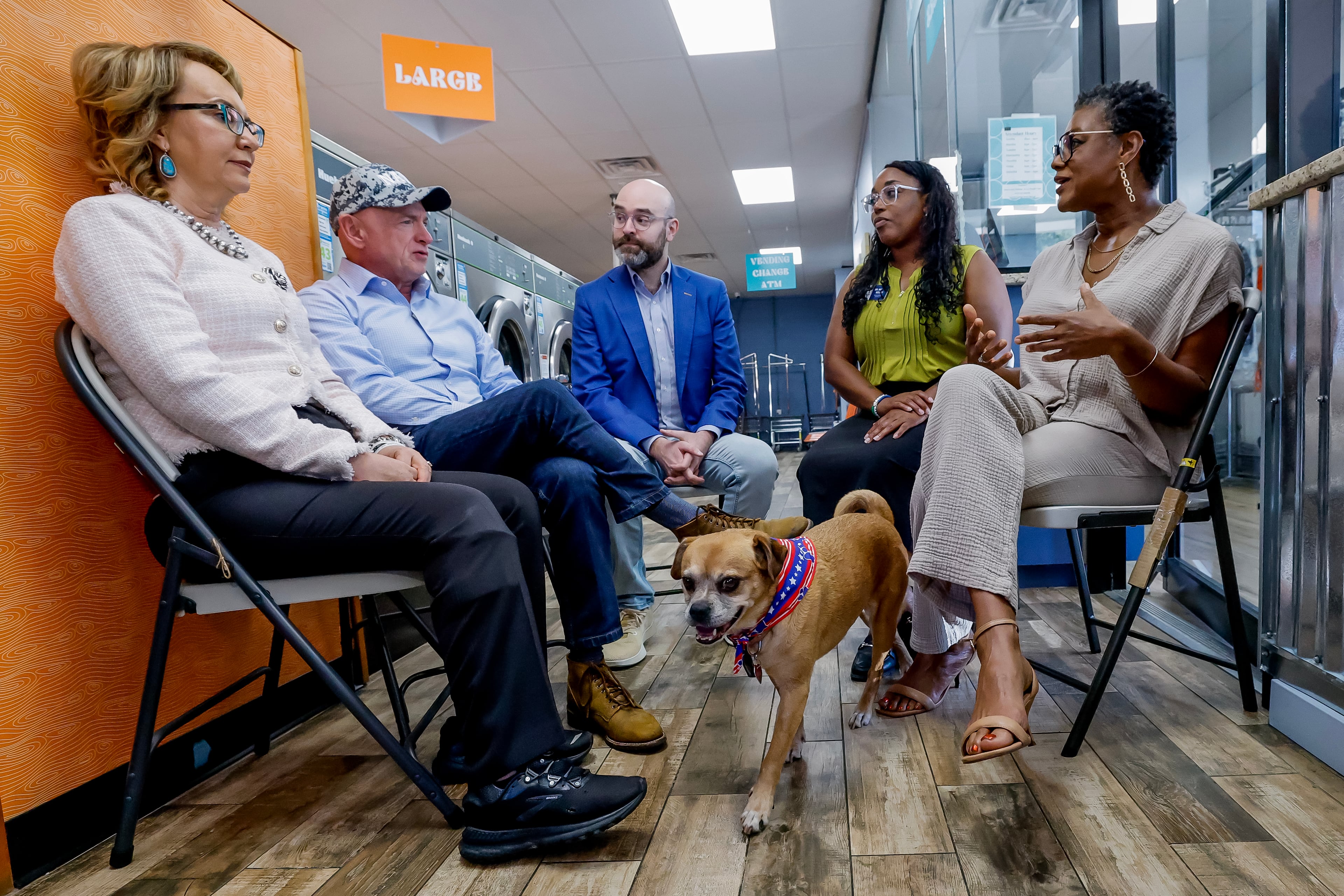 Former Arizona Rep. Gabby Giffords (from left) and her husband, U.S. Sen. Mark Kelly, meet with Democratic lieutenant governor nominee Sen. Josh McLaurin, Sandy Springs councilwoman Melody Kelley and business owner Sherwin Clemons, as Clemons’ dog, Foxxie, checks out the scene during a campaign stop of Democratic Party candidates and issues at the Laundry Lounge on Wednesday, Aug. 19, 2026 in Sandy Springs. (Erik S. Lesser for the AJC)