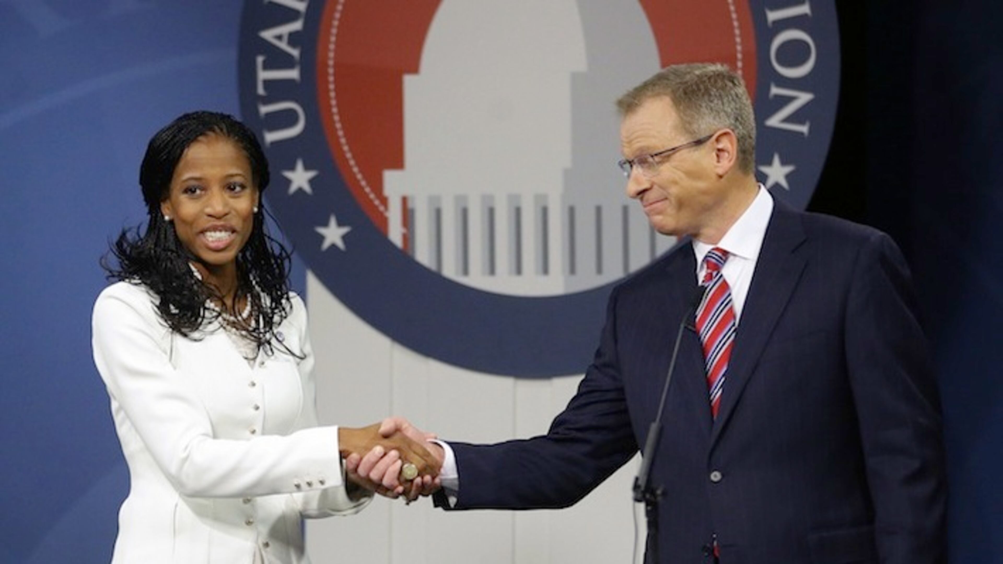 FILE - In this Oct. 14, 2014, file photo, Republican Mia Love and Democrat Doug Owens shake hands following their second debate in their race for Utah's 4th Congressional District, in Salt lake City. U.S. Rep. Love and her Democratic challenger Owens have added a combined million dollars to their campaign accounts so far this year as they prepare to face off again in November, Friday, April 15, 2016. (AP Photo/Rick Bowmer, File)