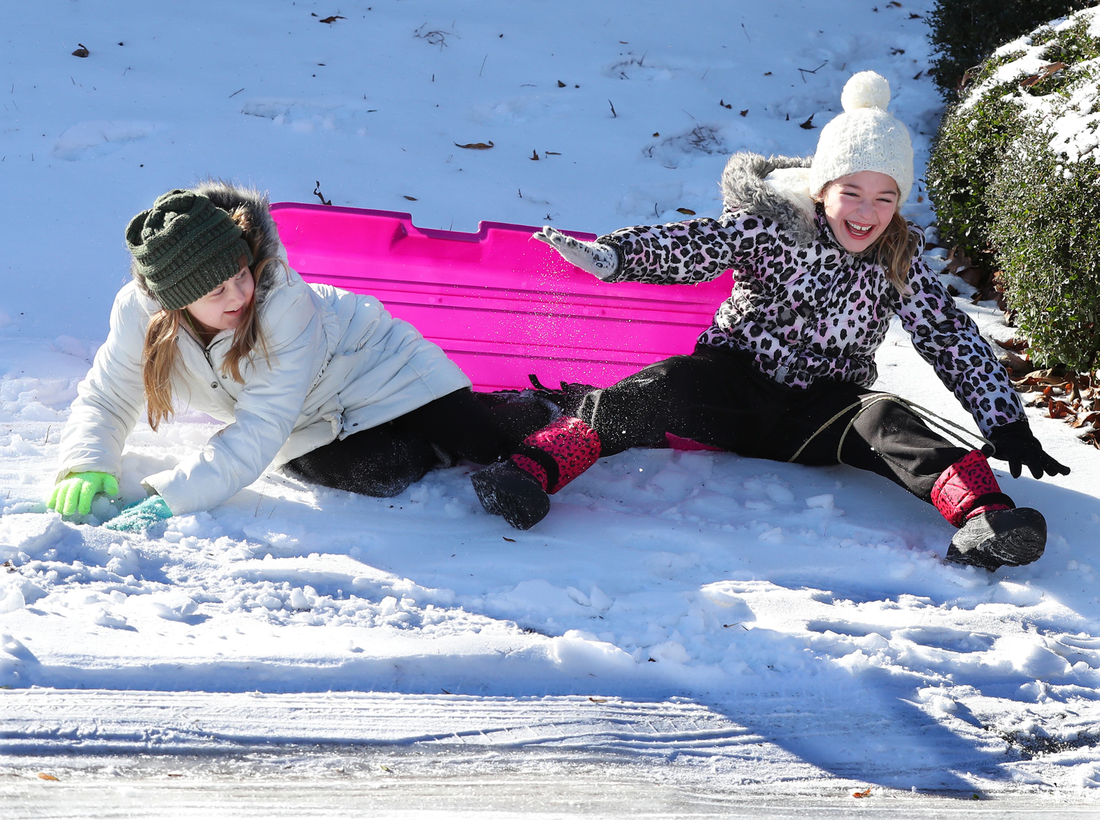 January 8, 2017, Canton: Lana Anderson (left) and Kaylee Collins share a laugh crashing into a snow covered bank while sleding in Cherokee Falls Estates at the Lake subdivision playing in the aftermath of the winter storm on Sunday, Jan. 8, 2017, in Canton. Curtis Compton/ccompton@ajc.com
