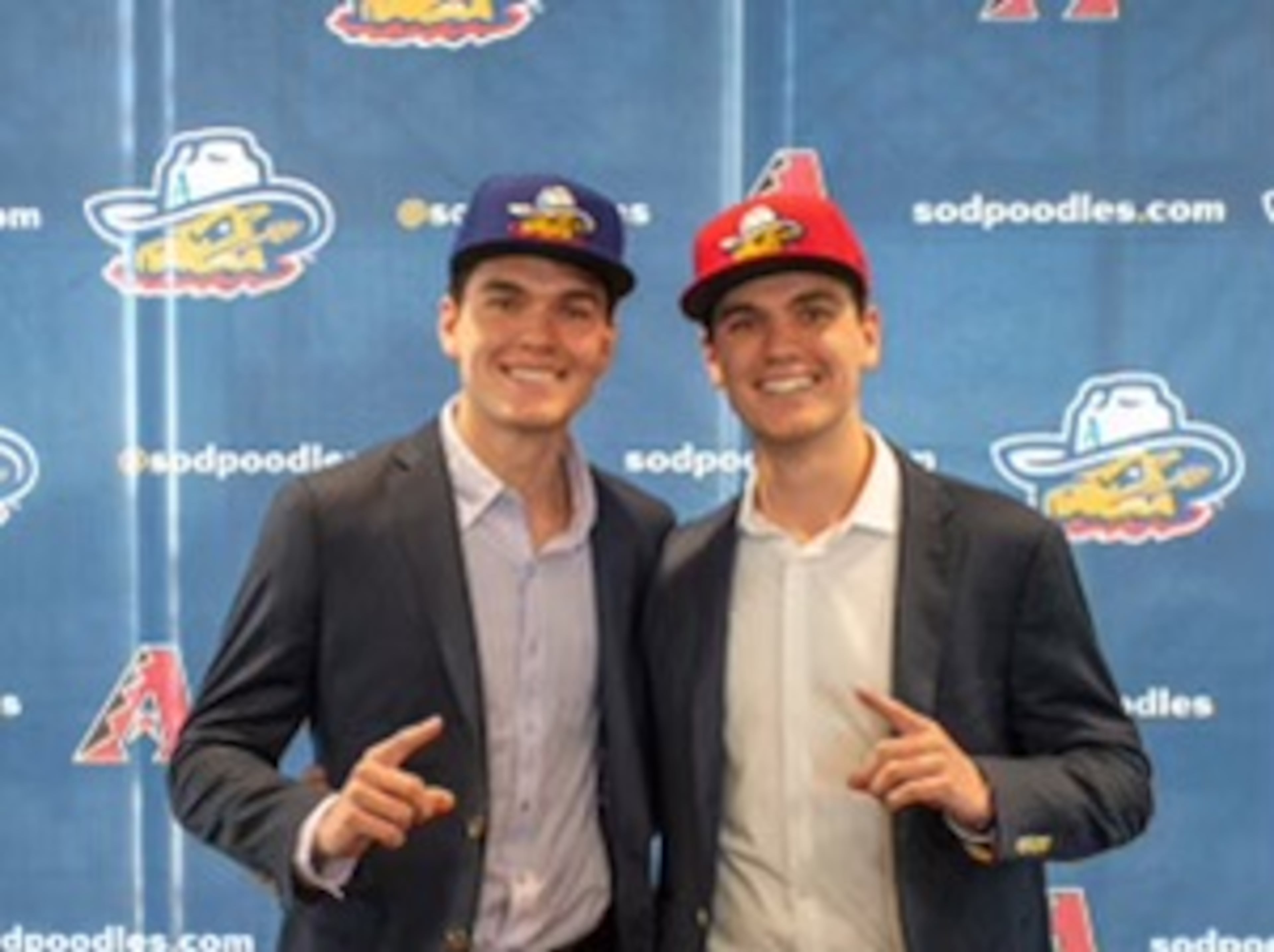 Twin brothers Stefan Caray (left, in blue cap) and Chris Caray (right, in red cap) after a press conference introducing them as the broadcasters for the Amarillo Sod Poodles minor-league baseball team. (Photo by Isaac Galan / Special to the AJC)
