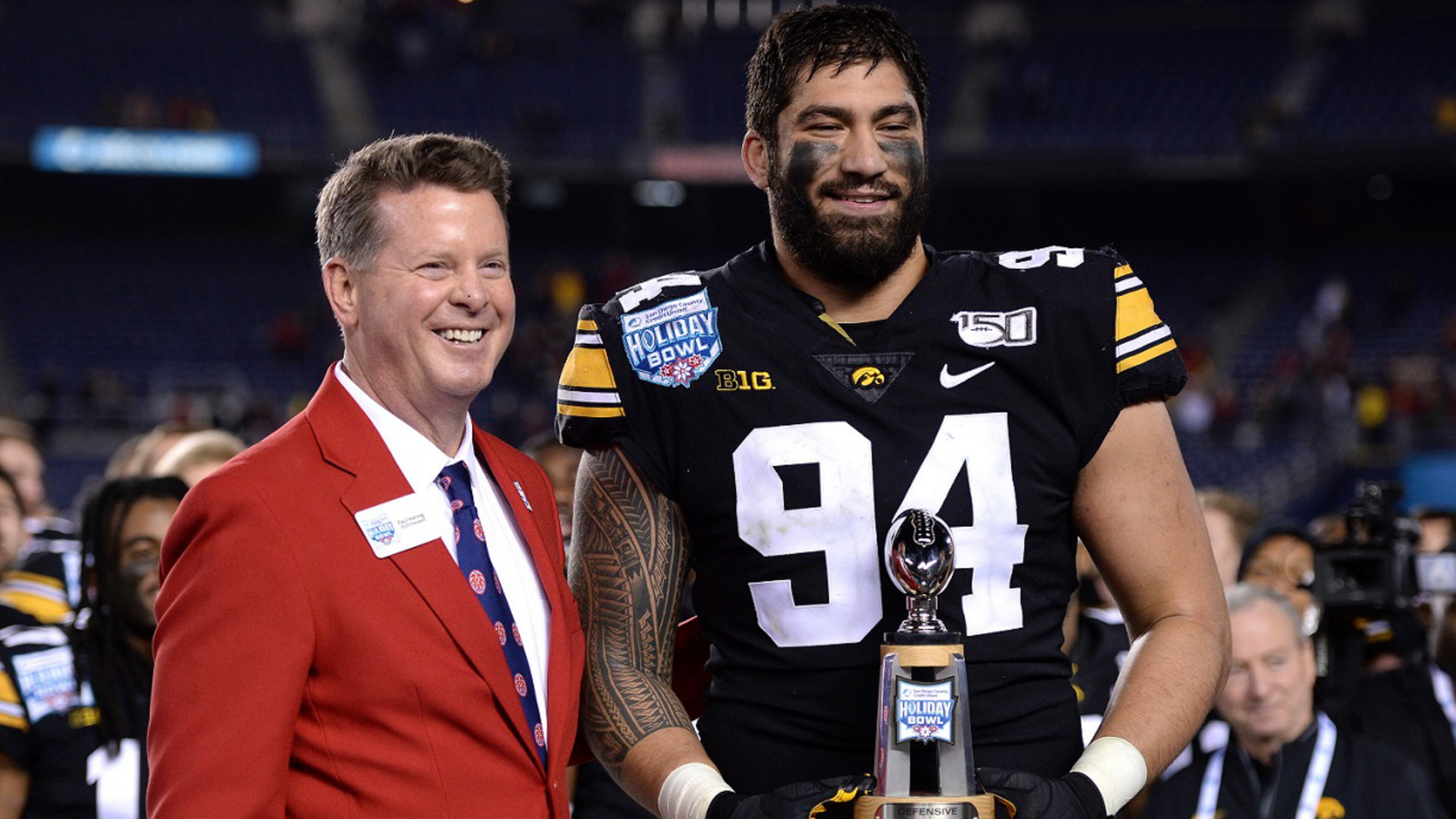 Iowa defensive end A.J. Epenesa, right, receives the defensive MVP trophy following the team's Holiday Bowl game against USC on Friday, Dec. 27, 2019, in San Diego. Iowa won 49-24. (AP Photo/Orlando Ramirez)
