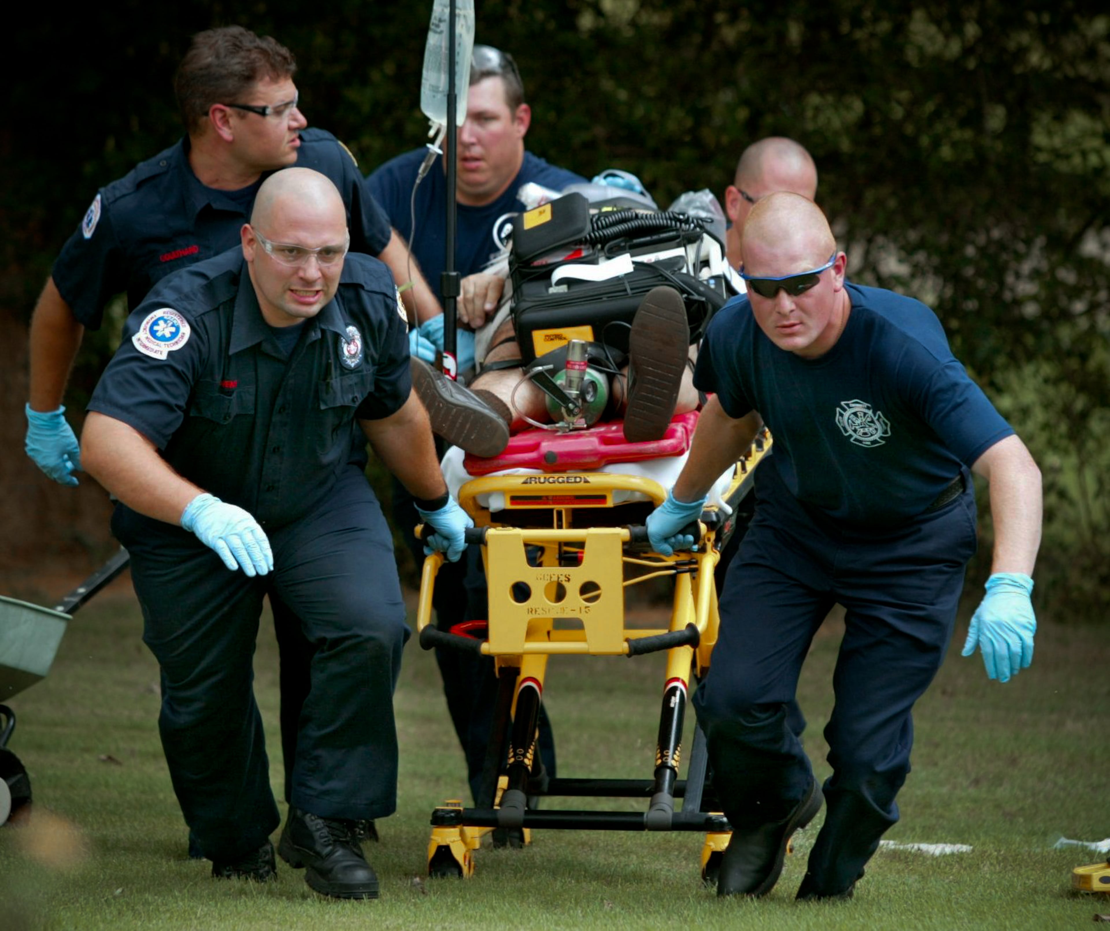 020826-08/26/02-JOHN SPINK/staff-/GWINNETT COUNTY- The Gwinnett County Firefighters of Station 15 in downtown Lawrenceville along with every U.S. Firefighter in America is recognized as a hero in today's post 911 American culture. Here (foreground left to right) Jamie Gowens and Blake McArthur and (background left to right) Steven Coulthard, Scott Spell and Gary Wirl -obscured) remove a cardiac patient from their Gwinnett County residence after performing CPR and other life saving measures.