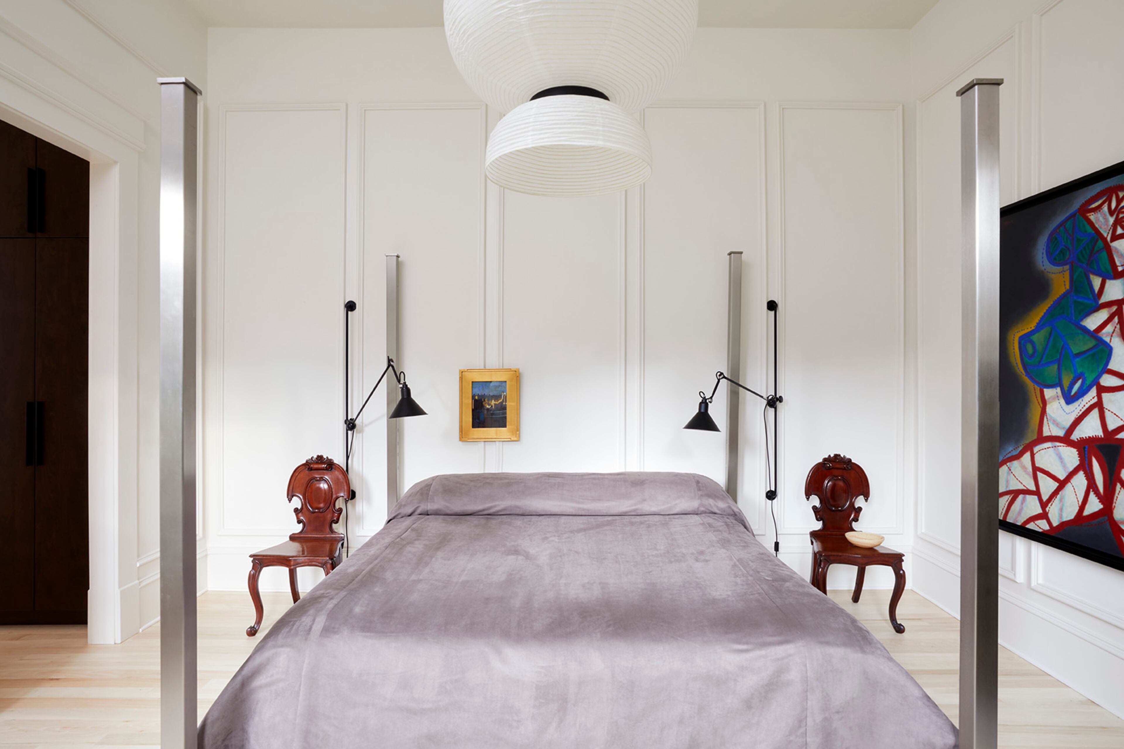 Modern materials mingle with more traditional forms in the elegant master bedroom. An impressive Lorin Marsh four-poster bed rests below a contemporary light fixture by Spanish designer Jaime Hayon. Photos by Gregory Miller Pictures.