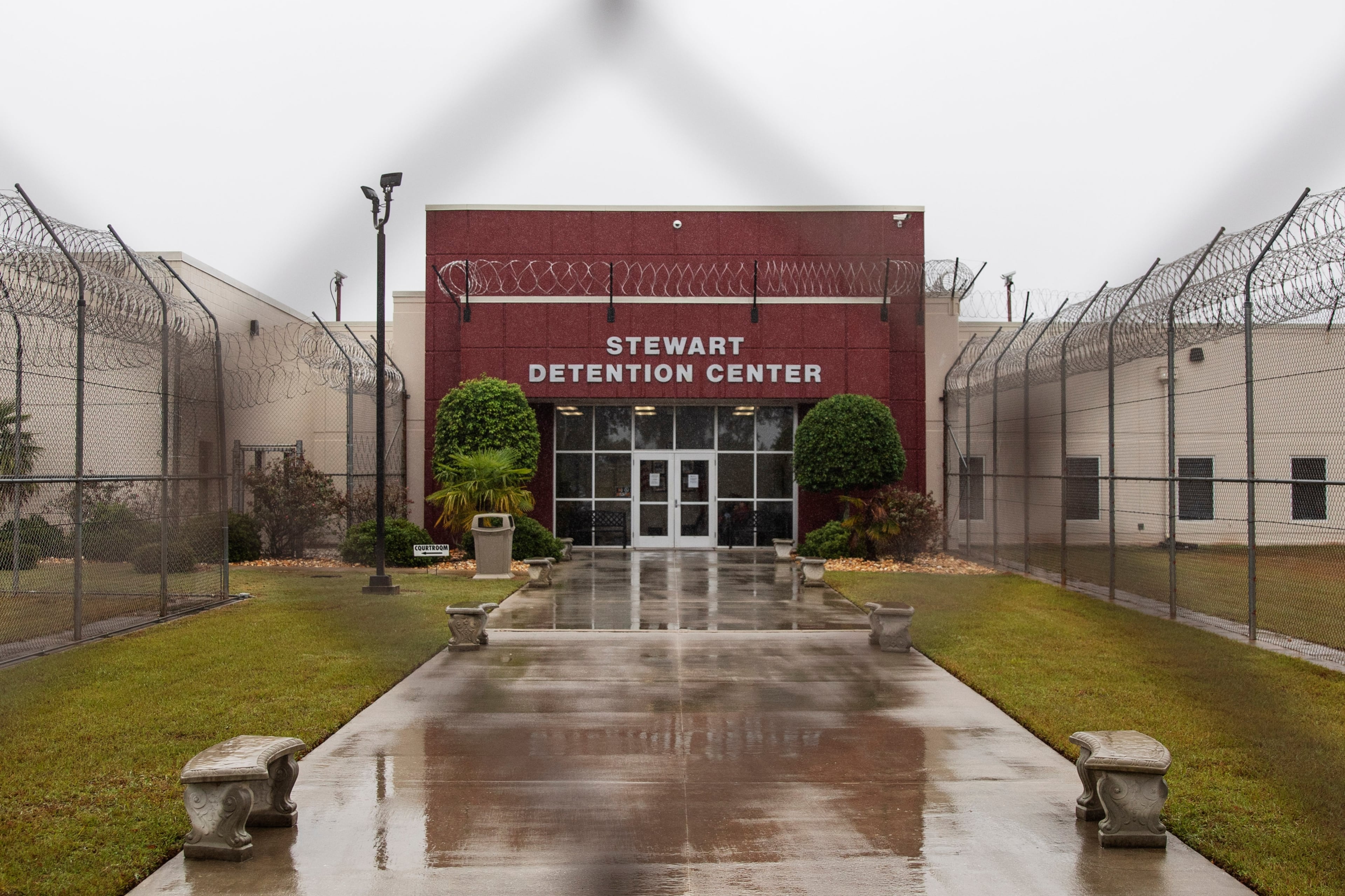 The Stewart Detention Center in Lumpkin, is seen through the front gate in this 2019 file photo. As of January, the facility held more than 2,000 detainees, according to ICE detention data. (David Goldman/AP)