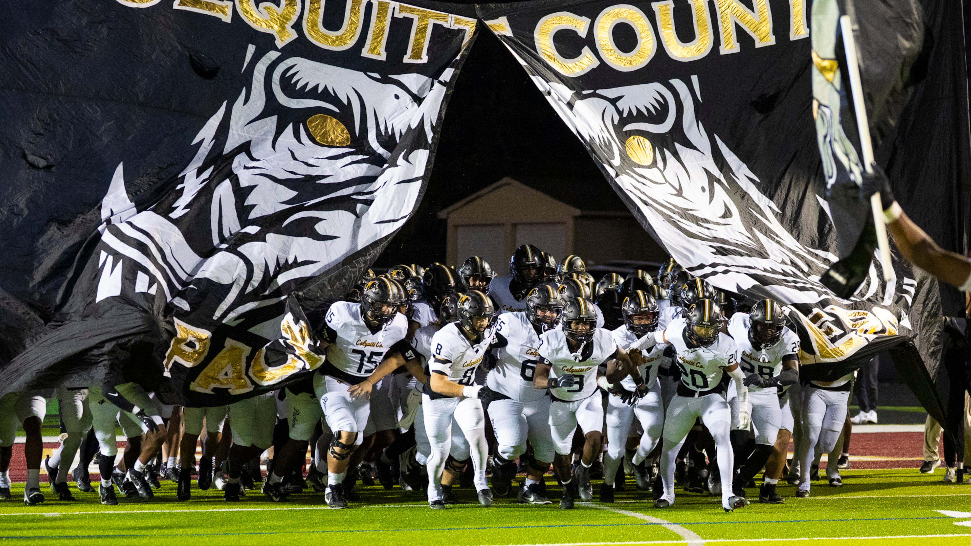 Colquitt County players (who call themselves the Packers) run through their Packer hog banner before their game against Mill Creek at Mill Creek Community Stadium, Friday, Nov. 14, 2025, in Hoschton. (Oscar Guevara Saenz for the AJC)