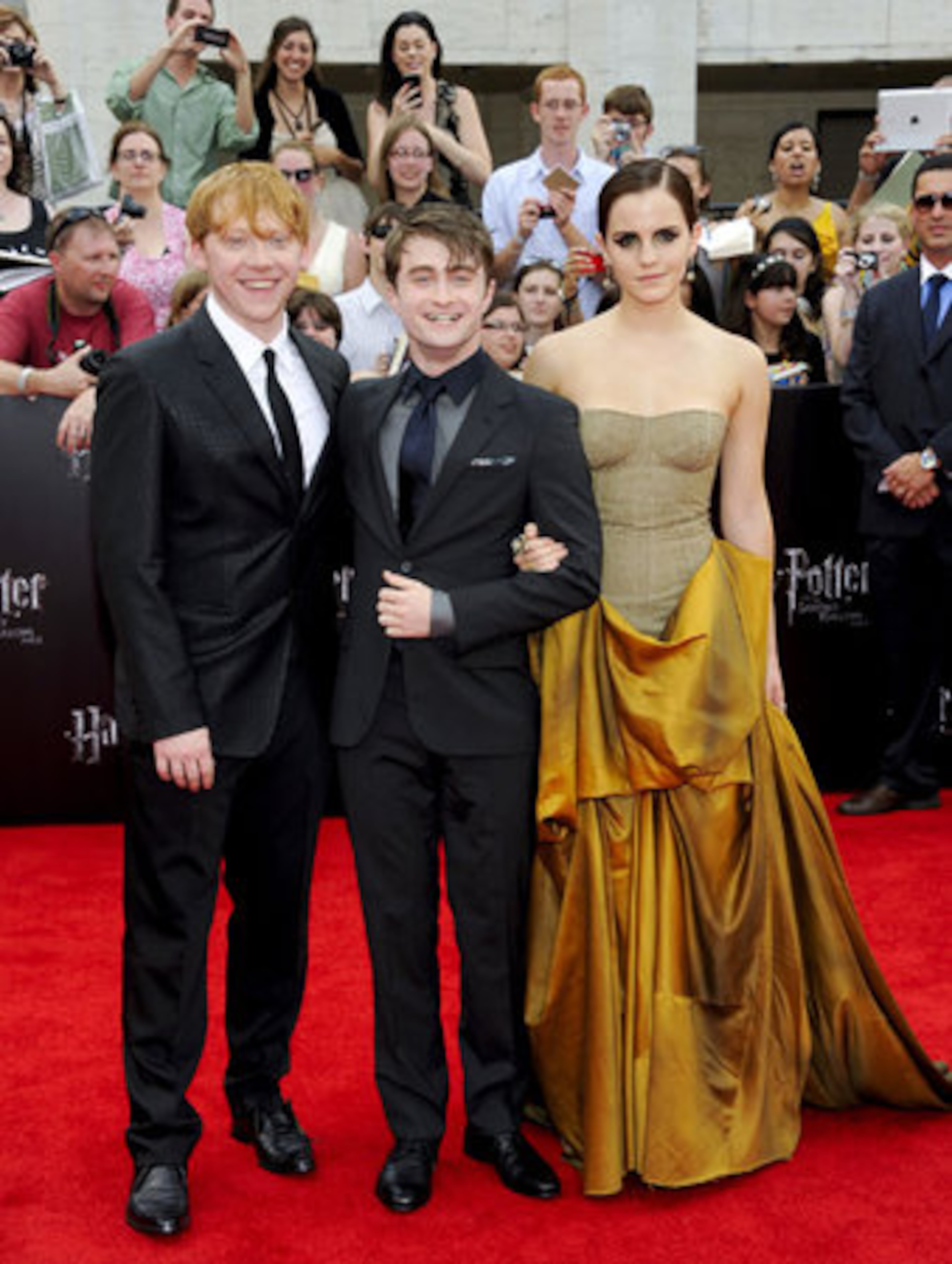 Cast members Rupert Grint, left, Daniel Radcliffe and Emma Watson, looking all grown up, pose on the red carpet at the premiere of the final "Harry Potter" film.