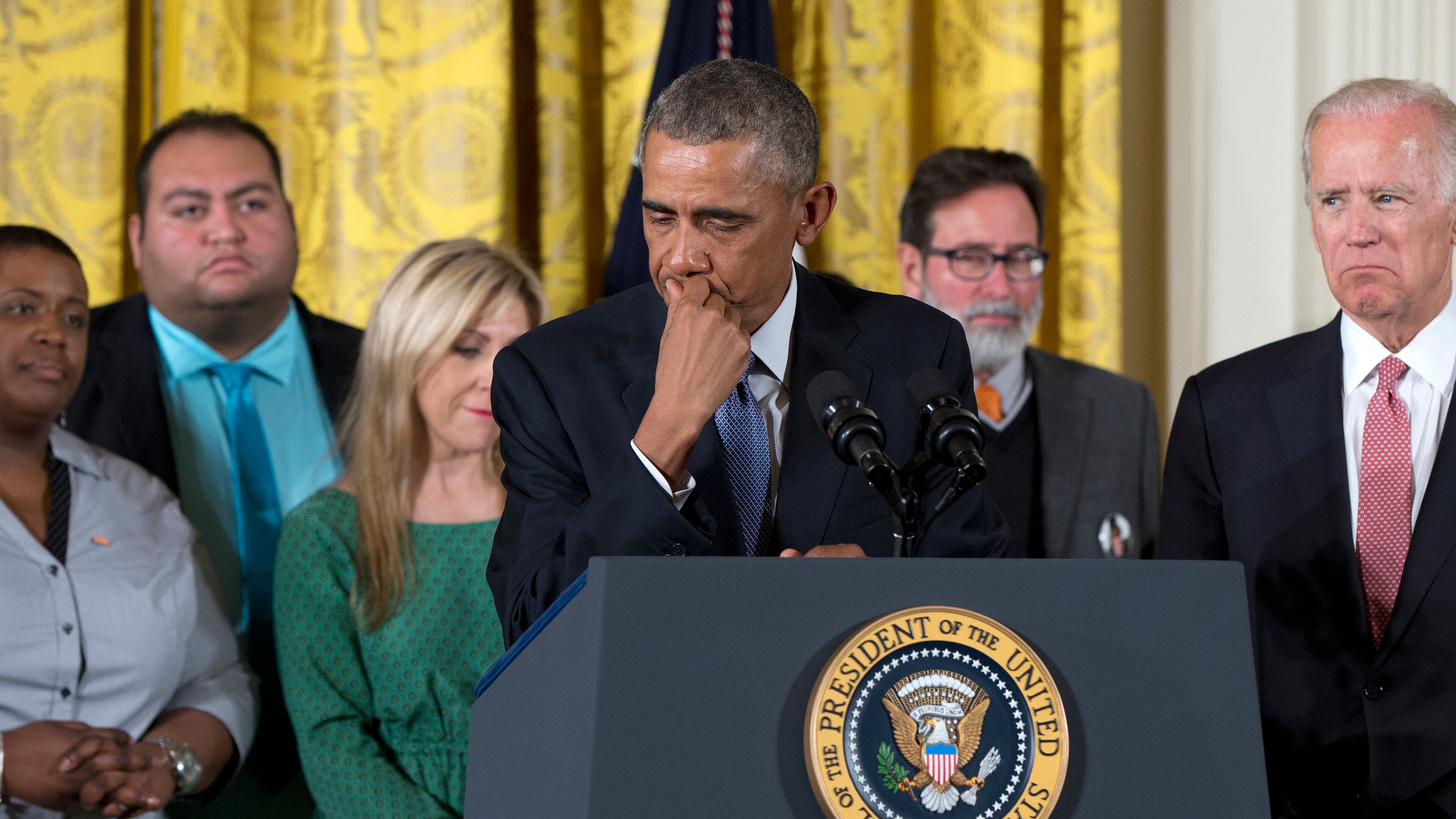President Barack Obama, joined by Vice President Joe Biden and gun violence victims, pauses as he speaks in the East Room of the White House in Washington, Tuesday, Jan. 5, 2016, about steps his administration is taking to reduce gun violence. Also on stage are stakeholders, and individuals whose lives have been impacted by the gun violence. (AP Photo/Carolyn Kaster)