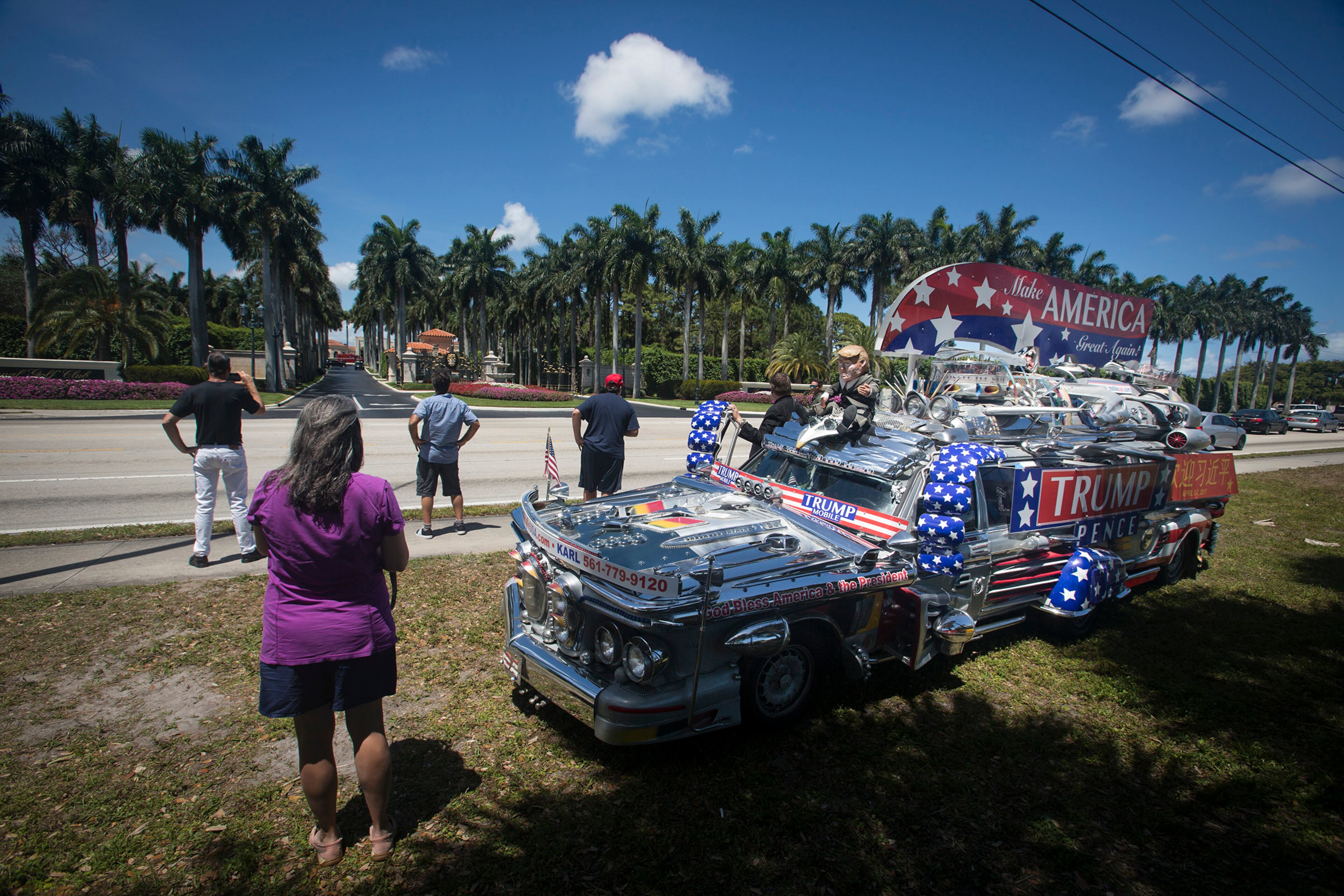 Supporters wait across the street from Trump International Golf Club in hopes of catching a glimpse of President Donald Trump's motorcade Friday, April 14, 2017. Among them was Pastor Martti Falck, who drove the Trump Mobile. Pastor Falck said had a cross to give to President Trump, in case he stopped. "I want to give him the cross to say that Christians are praying for America and President Trump," Falck said. "We know it is a lonely and tough job. We need to pray for wisdom and a united America." Falck said the Trump Mobile was built by a friend of his over 12 years using parts from 43 different cars. (Bruce R. Bennett / The Palm Beach Post)