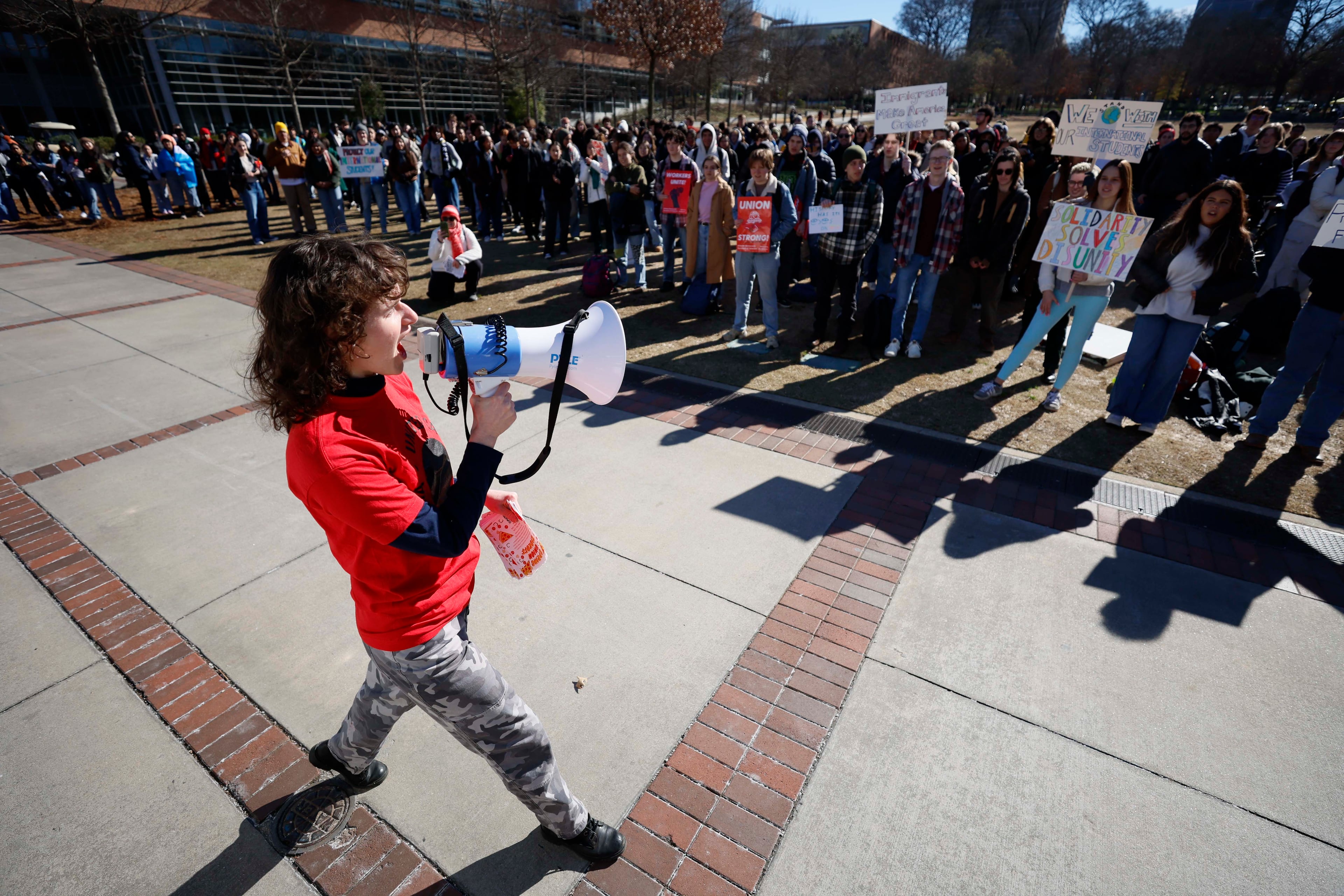 Julia Byrne with the United Campus Workers Union speaks during the walkout rally at Tech Green on the main campus on Tuesday, Jan. 20, 2026. The demonstration coincided with the anniversary of Trump’s inauguration and opposed increased immigration enforcement during his administration. (Miguel Martinez/AJC)