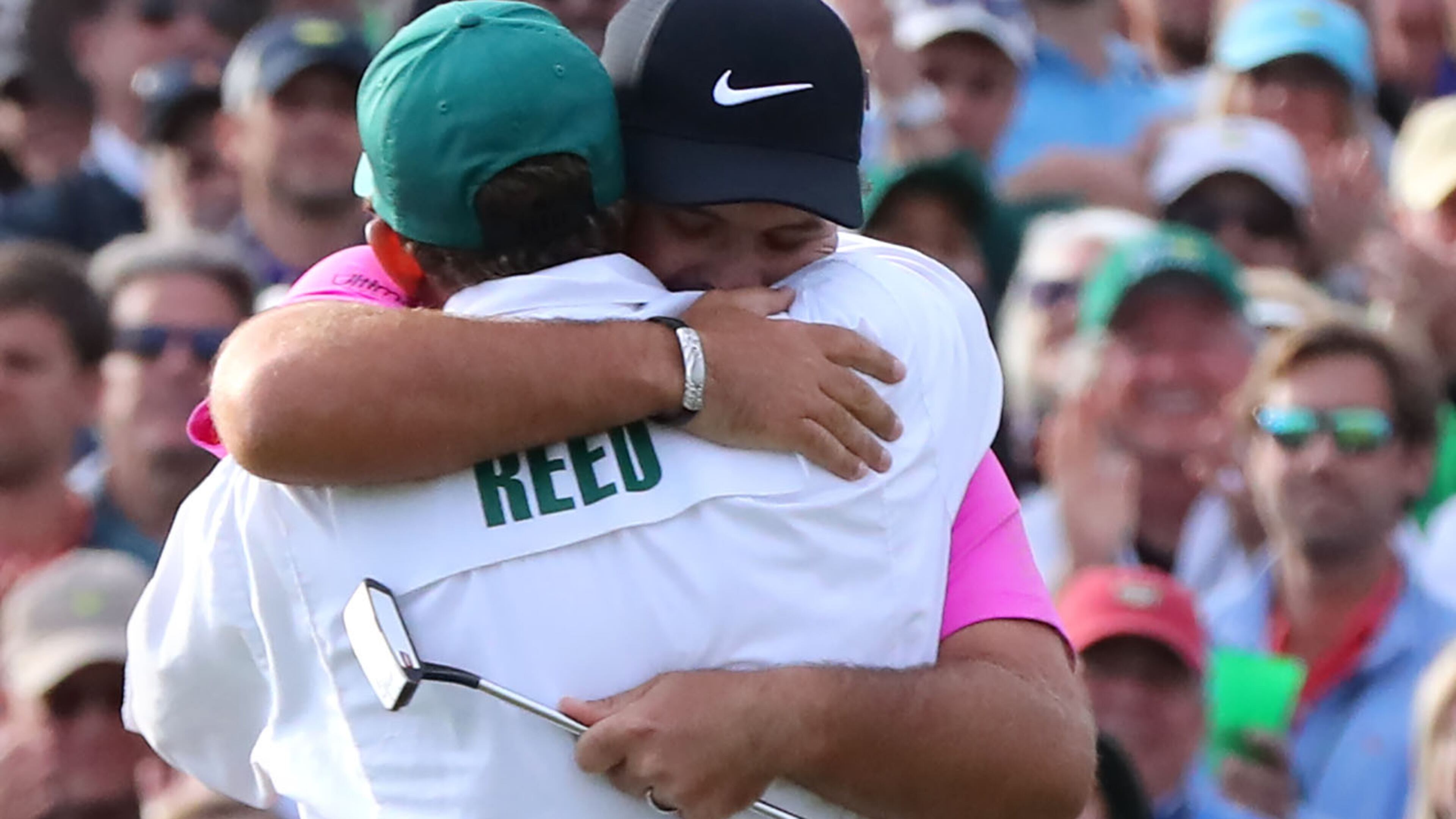 Patrick Reed hugs his caddy Kessler Karain after making a par putt on the 18th green to win the Masters Tournament Sunday, April 8, 2018, at 15-under par at Augusta National Golf Club.