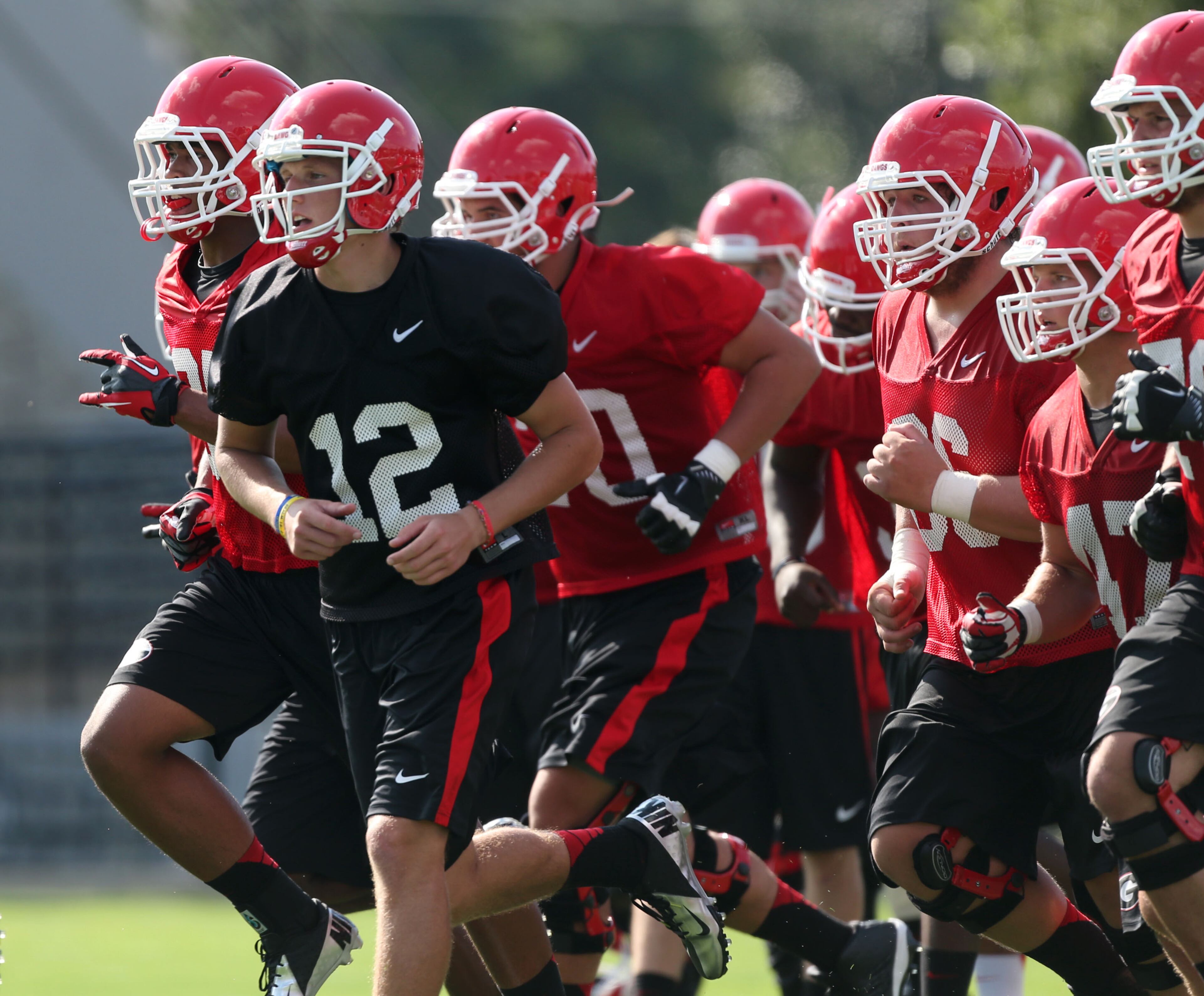 University of Georgia freshman quarterback Brice Ramsey (12) runs toward a drill with offensive lineman during the first day of practice at the University of Georgia Thursday afternoon in Athens, Ga., August 1, 2013. JASON GETZ / JGETZ@AJC.COM